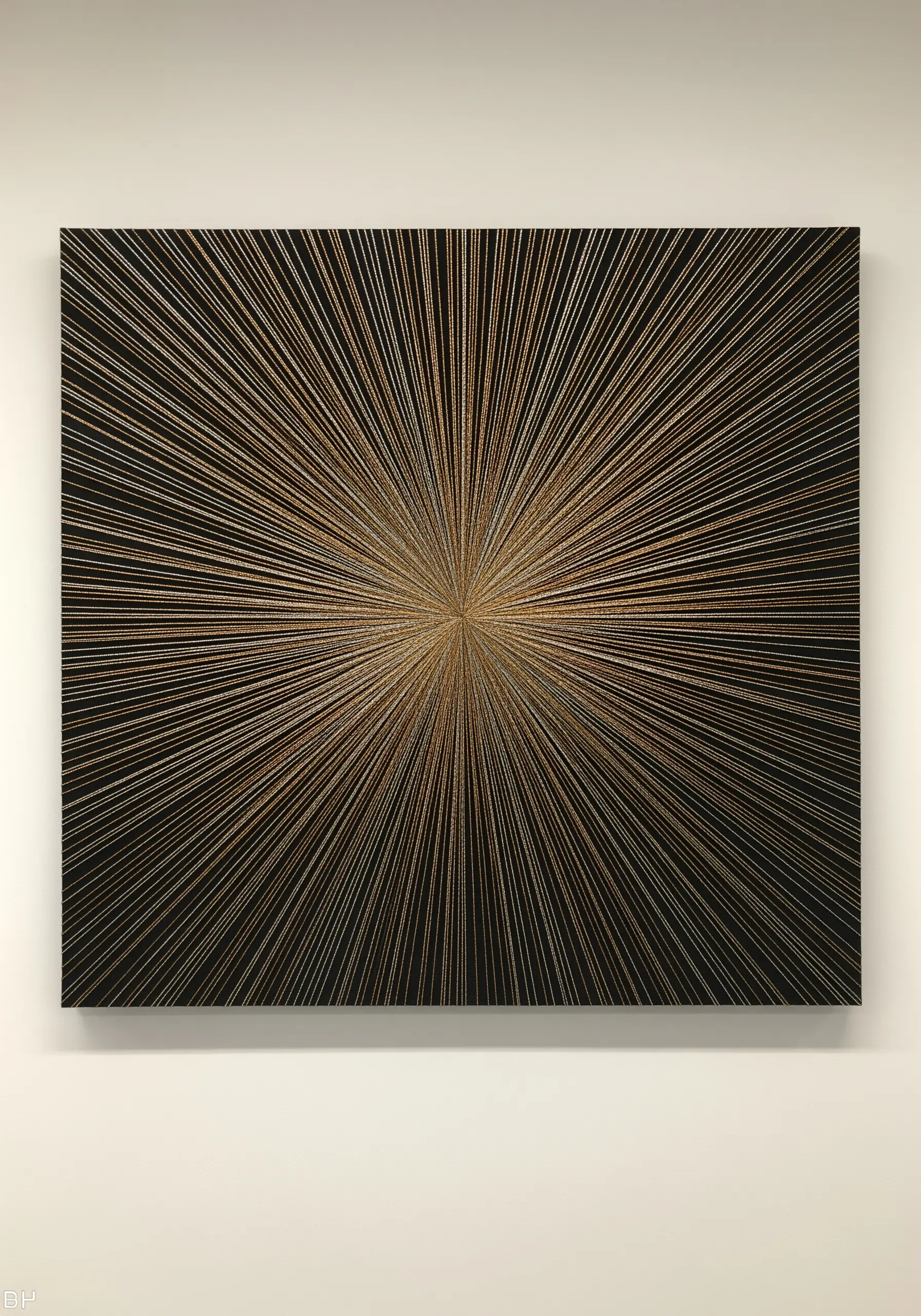 A square black canvas covered in radiating lines of metallic thread, creating a starburst effect.