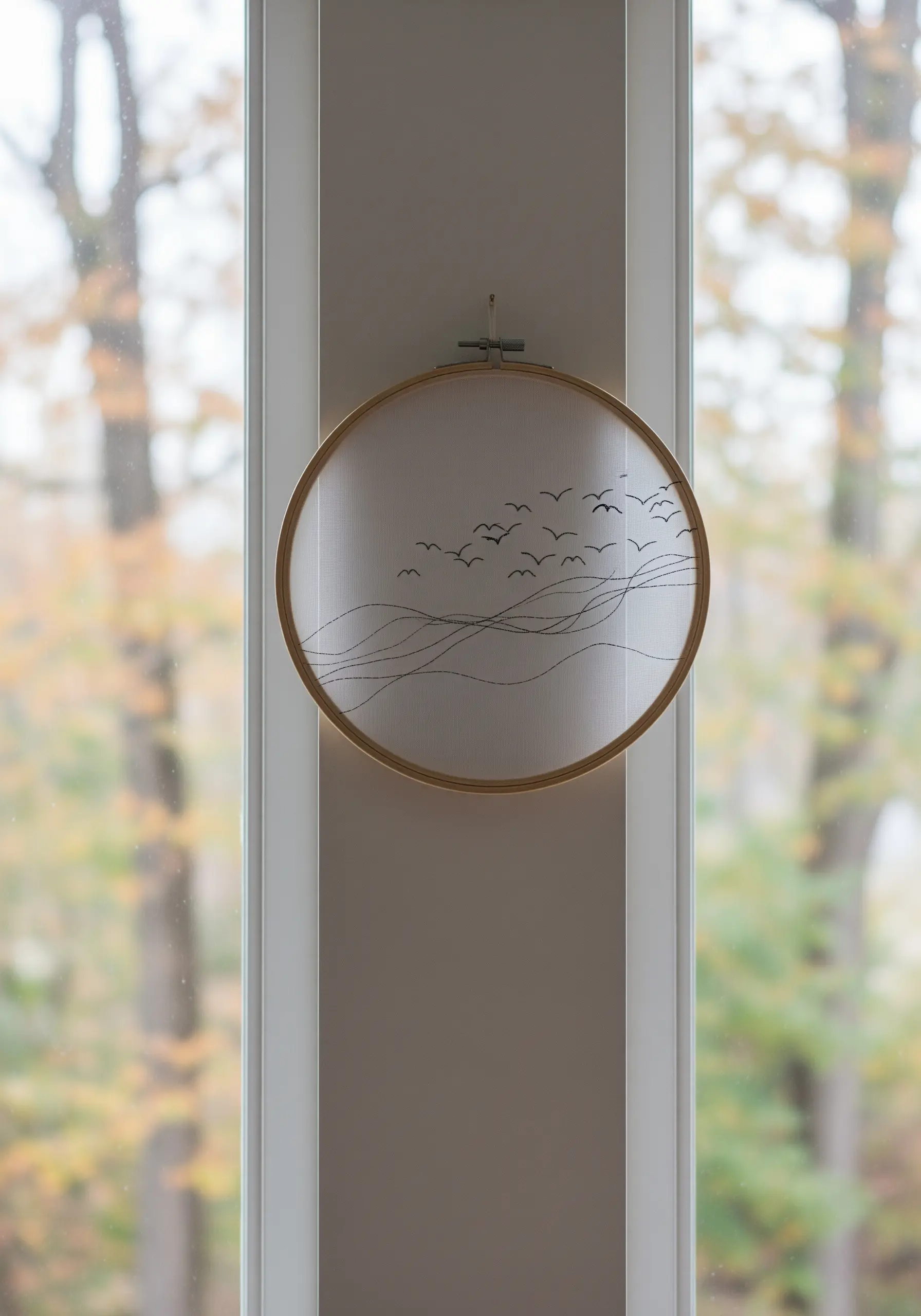 A flock of birds and wave-like lines embroidered on sheer fabric, creating a floating effect.