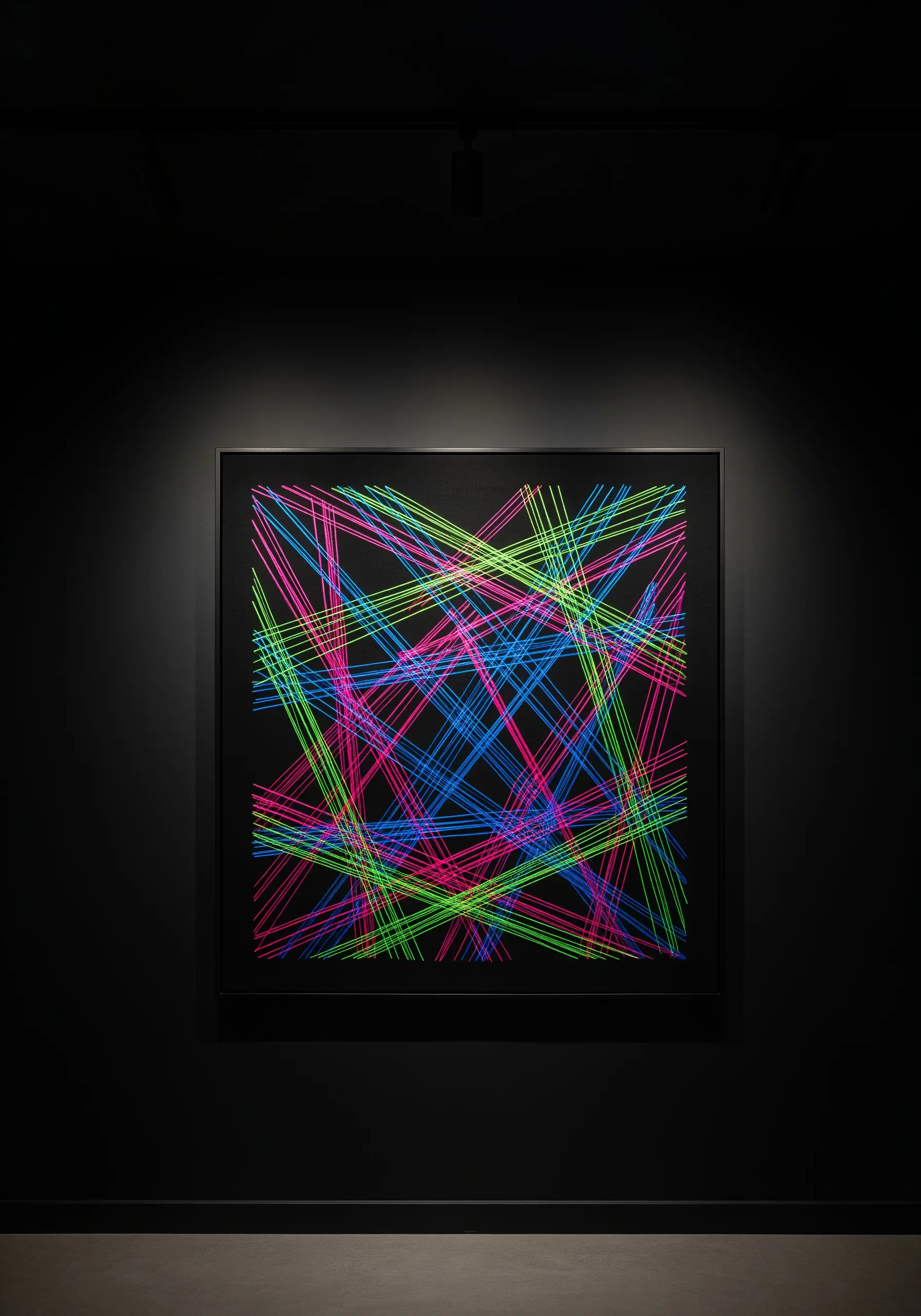 Abstract embroidery with intersecting neon pink, green, and blue lines on a black background.