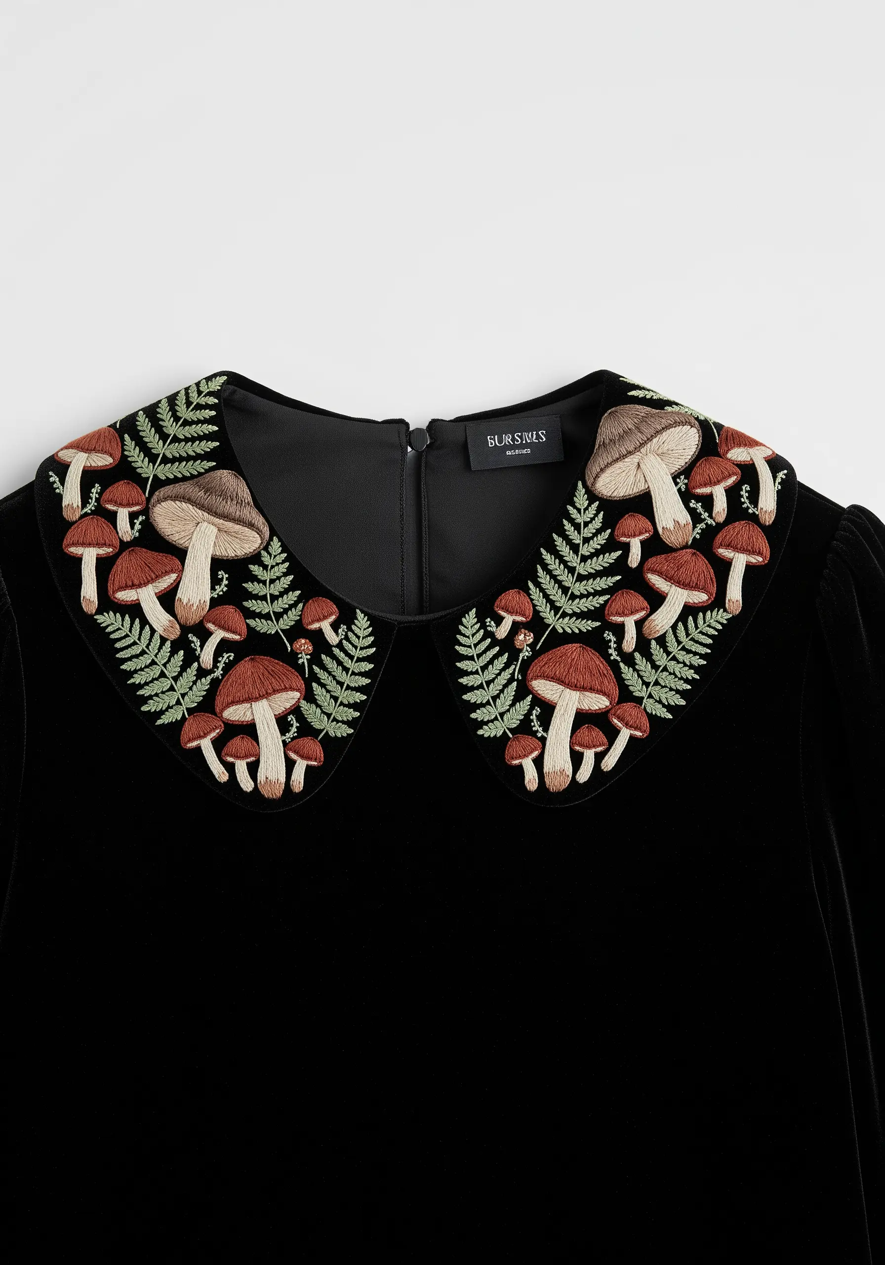 A collar on a black velvet dress embroidered with a dense pattern of mushrooms and ferns.