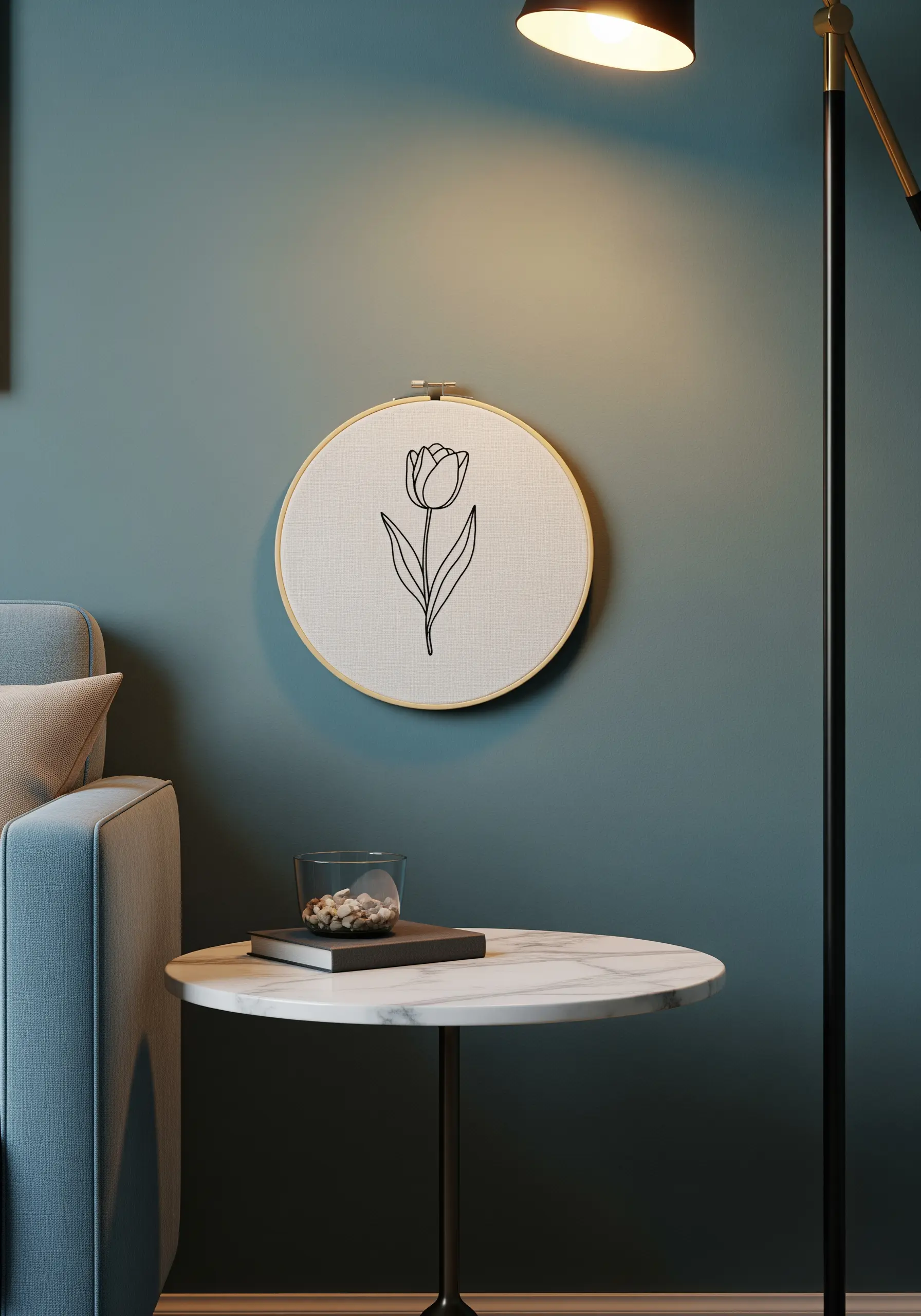A single tulip embroidered in a bold black outline on white fabric in a hoop.