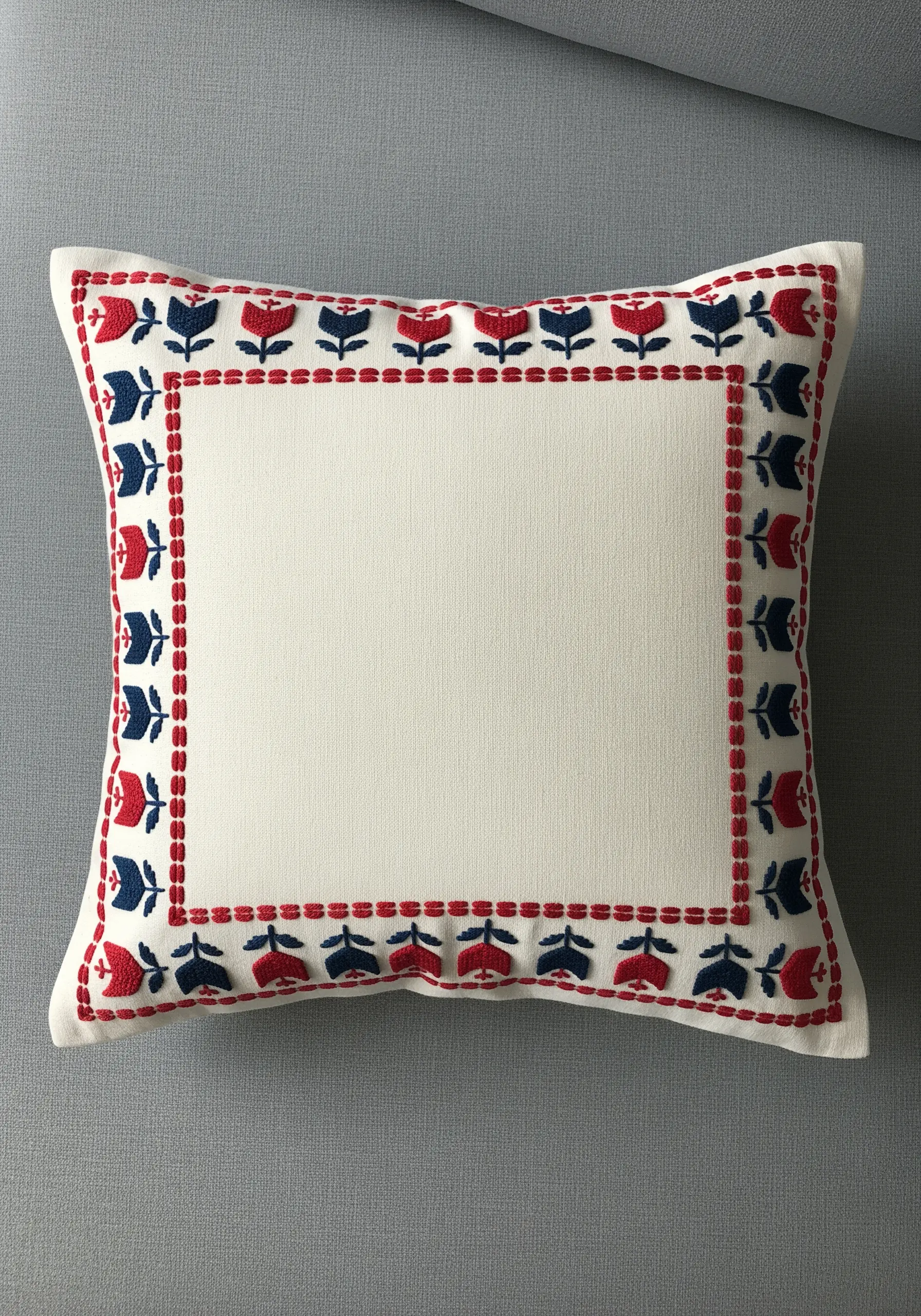 Folk art style embroidered border with red and blue tulips on a cream cushion