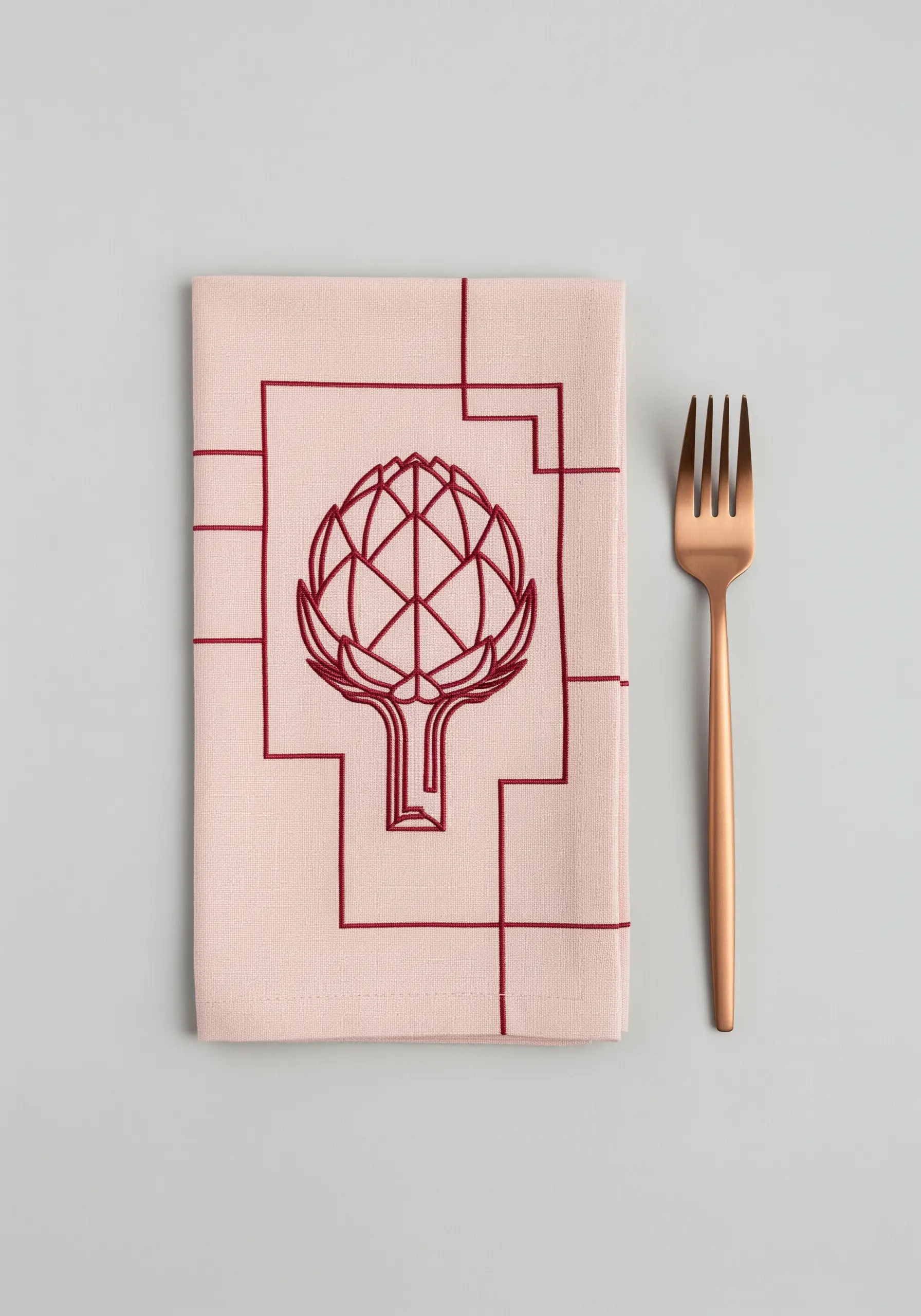 Red Art Deco style artichoke embroidered on a pale pink linen napkin.