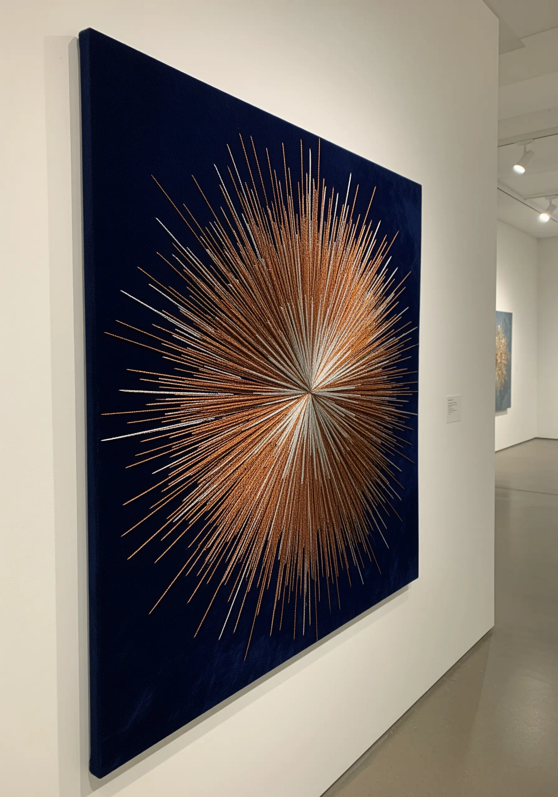 A large copper and silver metallic thread starburst embroidered on dark blue velvet.