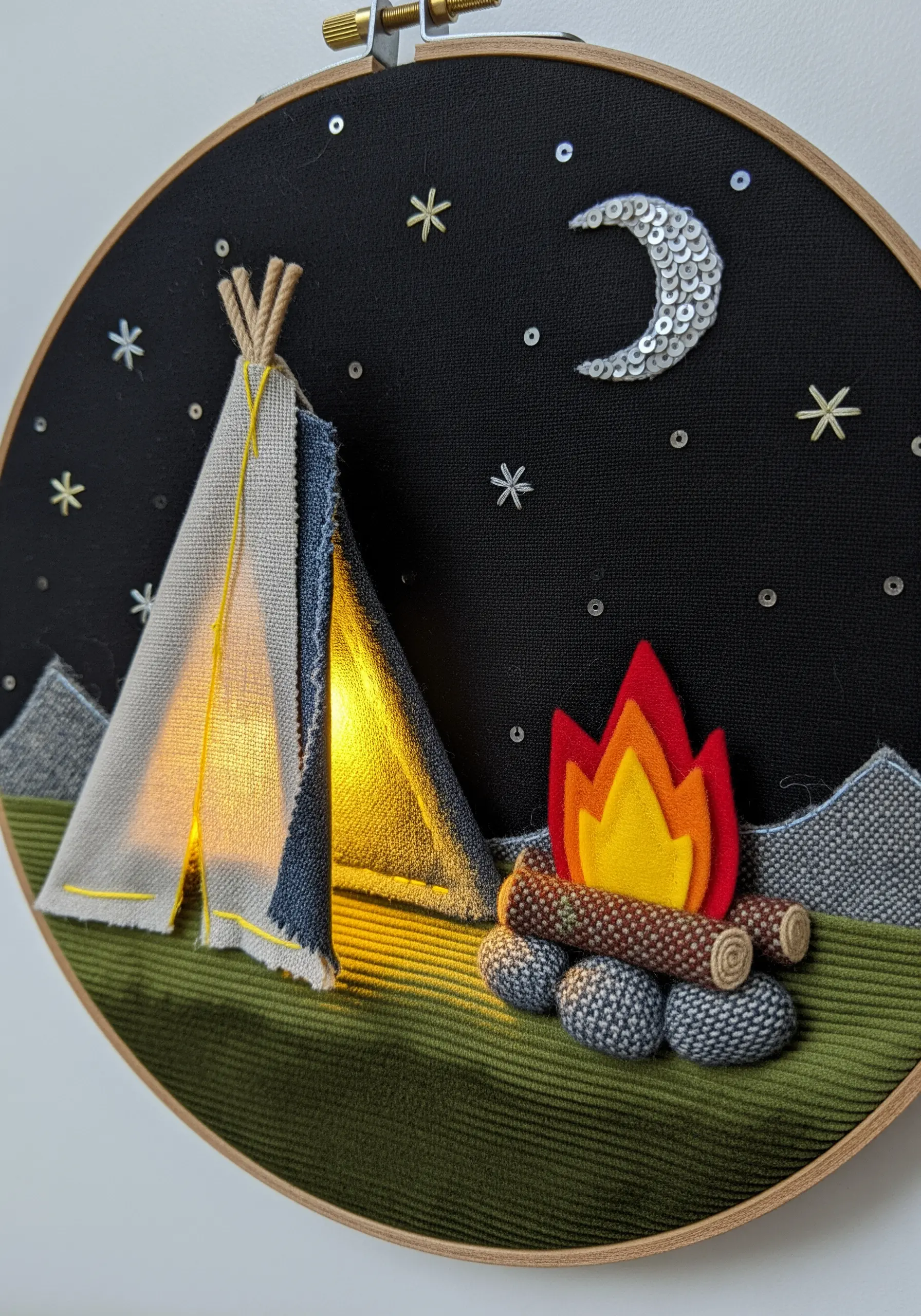 A campsite hoop art scene with a real LED light glowing inside the fabric tent