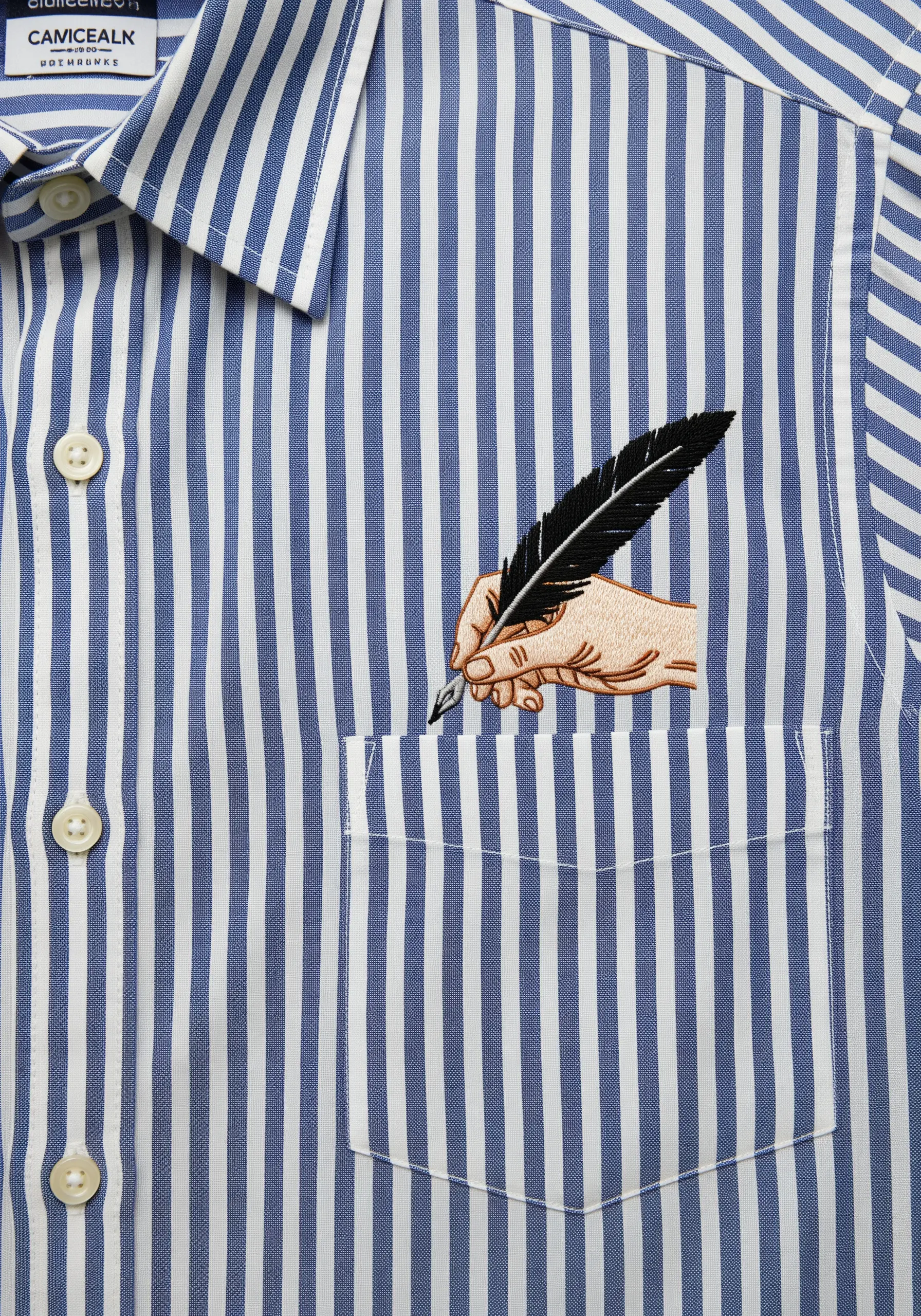 Embroidery of a hand holding a feather quill, positioned to look like it's coming out of a shirt pocket.
