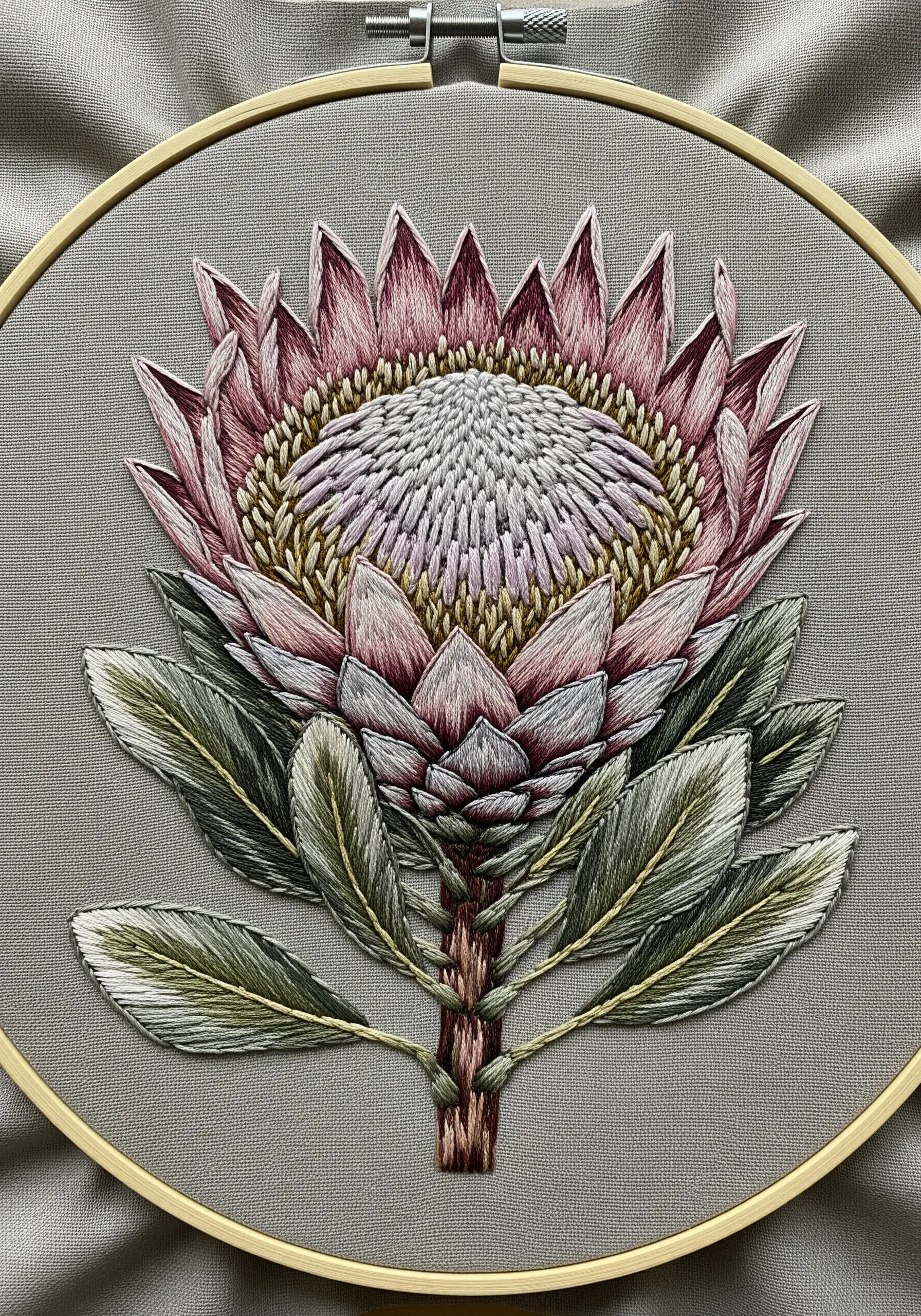 Highly detailed embroidery of a King Protea flower with dense, textured stitching.
