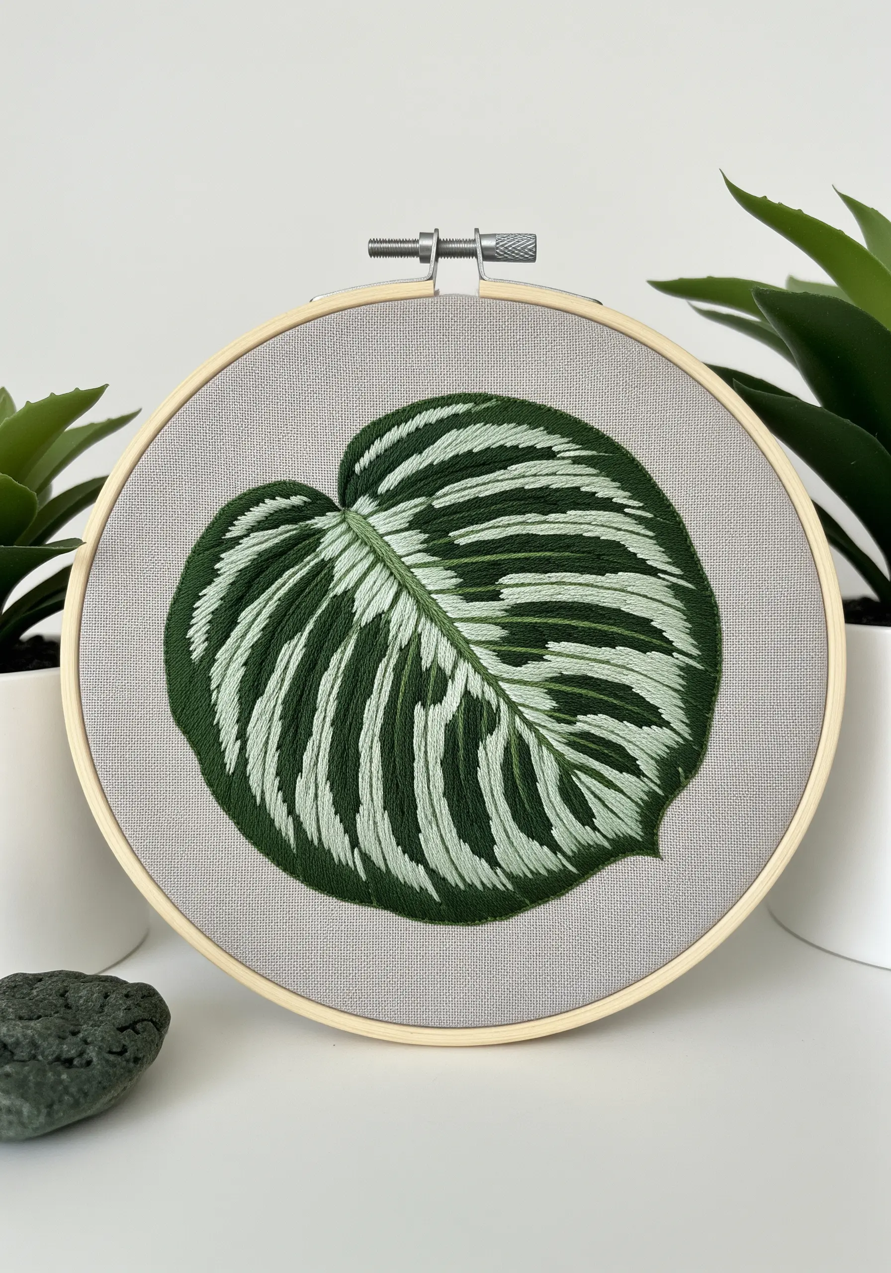 A calathea leaf with clean, contrasting stripes of dark green and white satin stitch.
