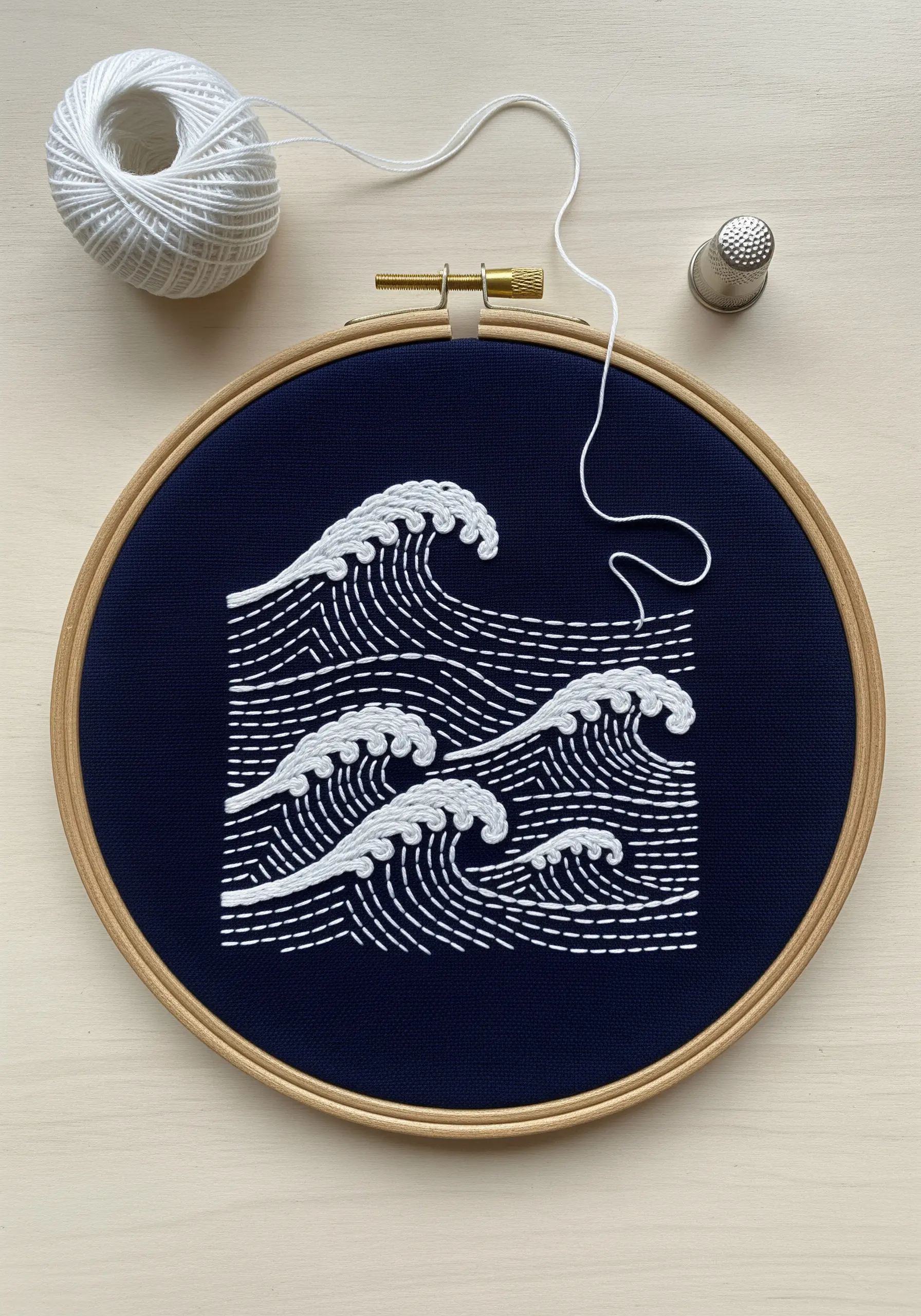 Japanese-style waves embroidered in white thread on navy blue fabric.
