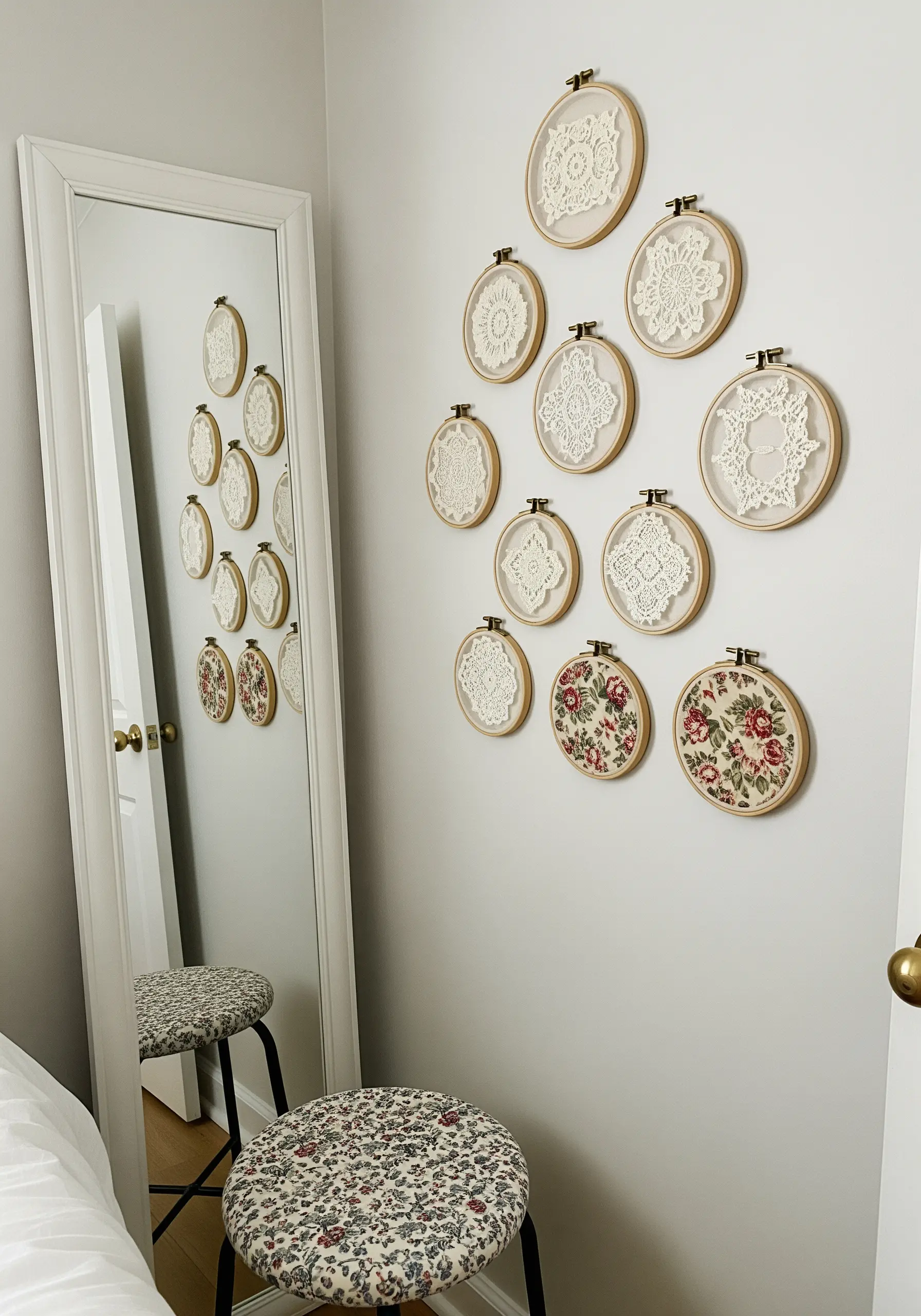 A wall display mixing embroidered floral hoops with hoops framing vintage lace doilies.
