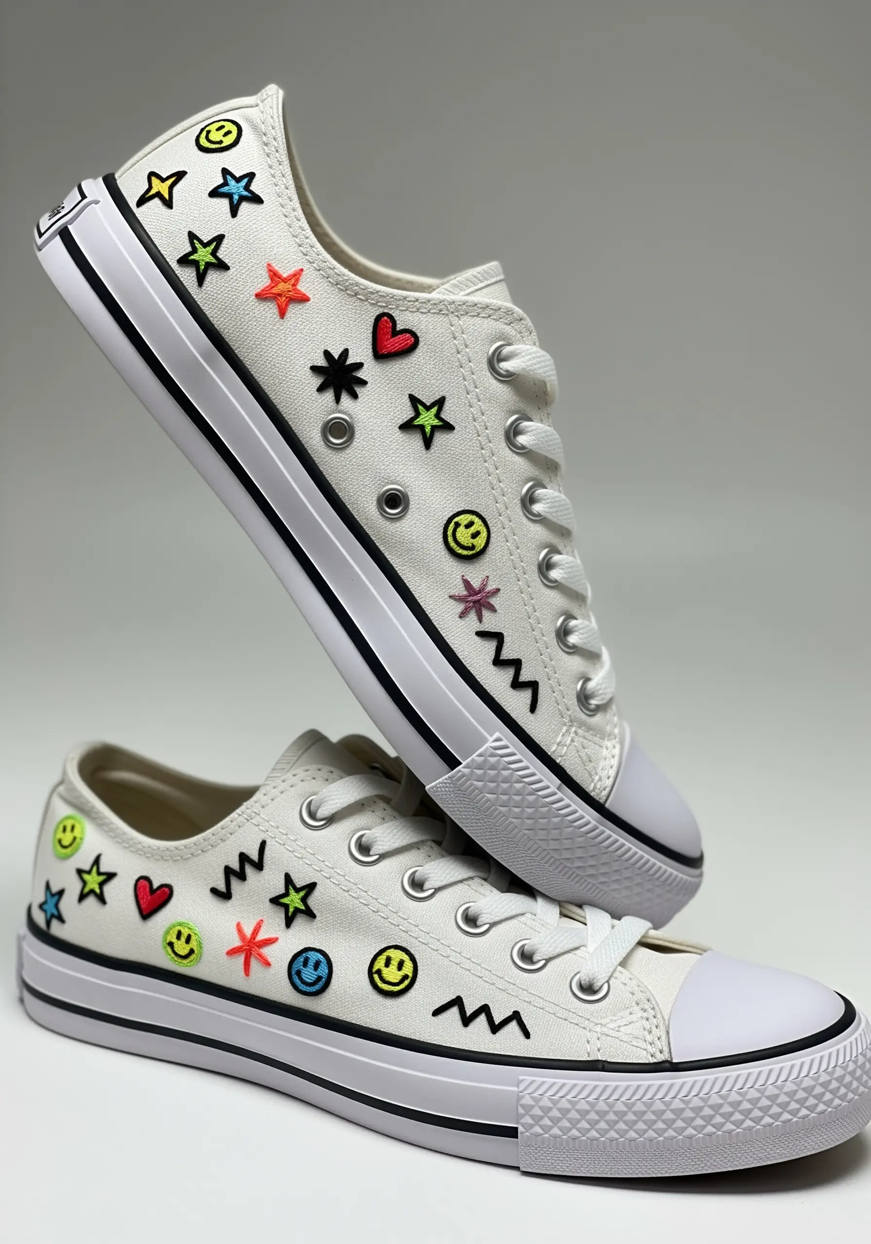 White canvas sneakers embellished with small, colorful embroidered doodles like stars and hearts.