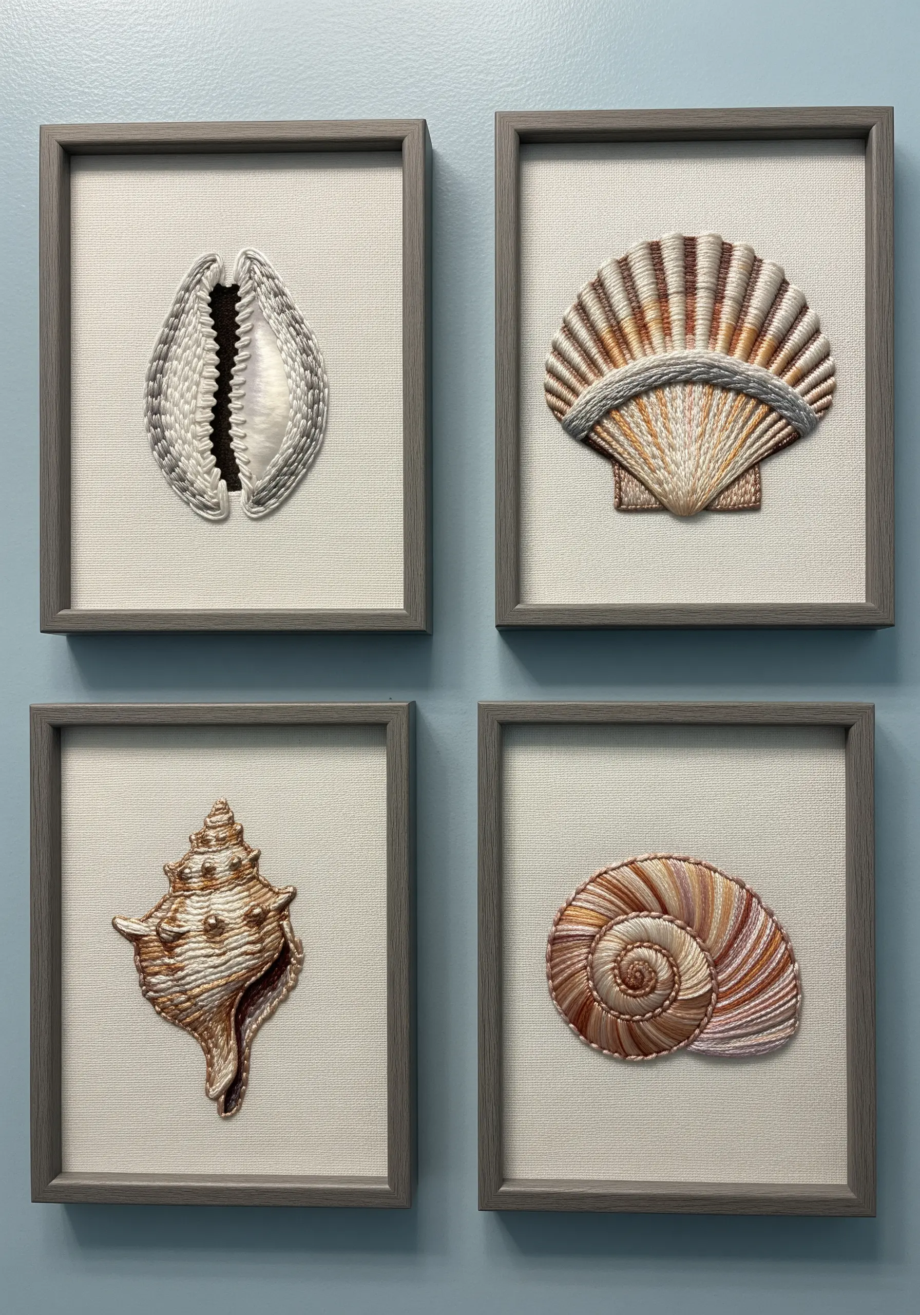 Four framed embroidery pieces, each depicting a different, highly realistic seashell with 3D texture.