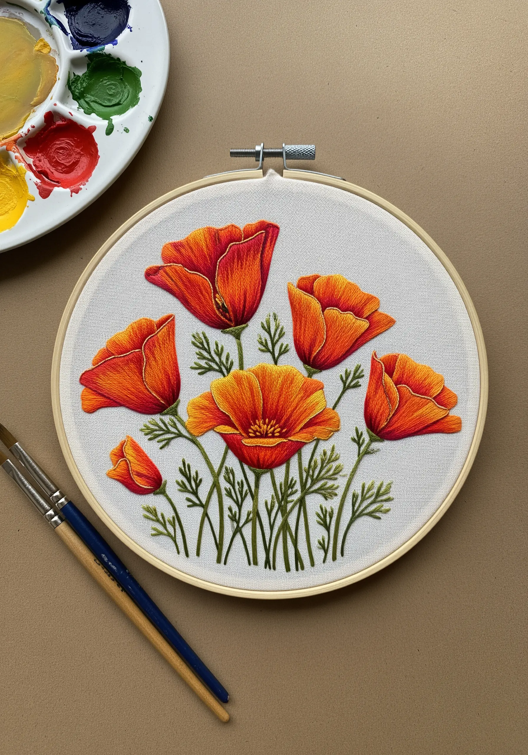Vibrant orange and red California poppies embroidered with thread-painting techniques on white fabric.