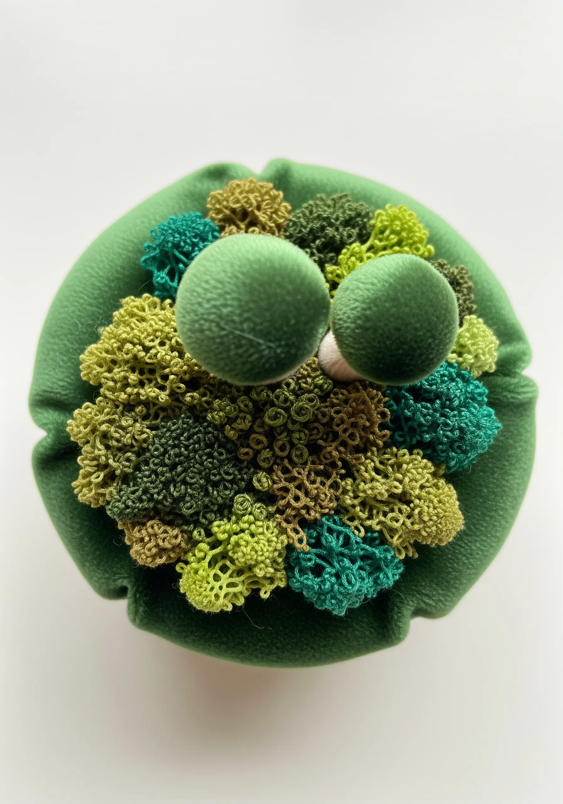 A 3D embroidery sculpture of various green mosses made with dense knots.