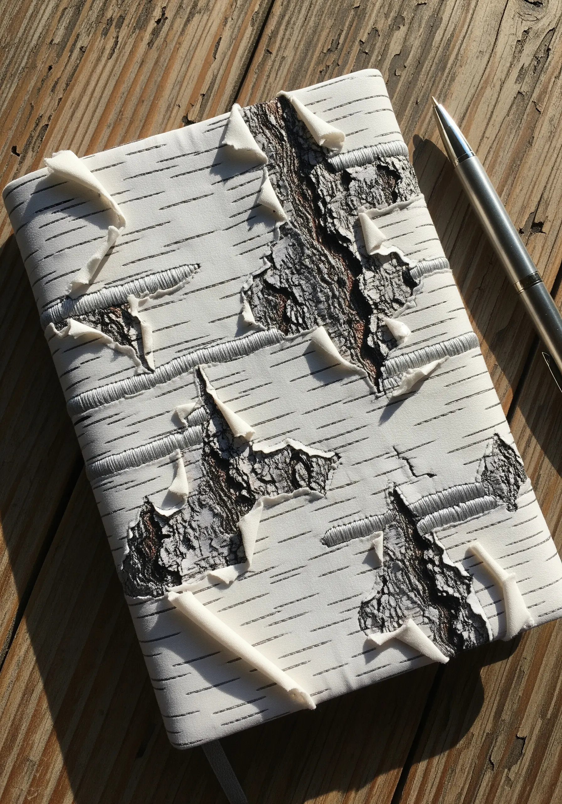 A journal cover decorated to look like birch bark, using layered fabric and minimal stitching.