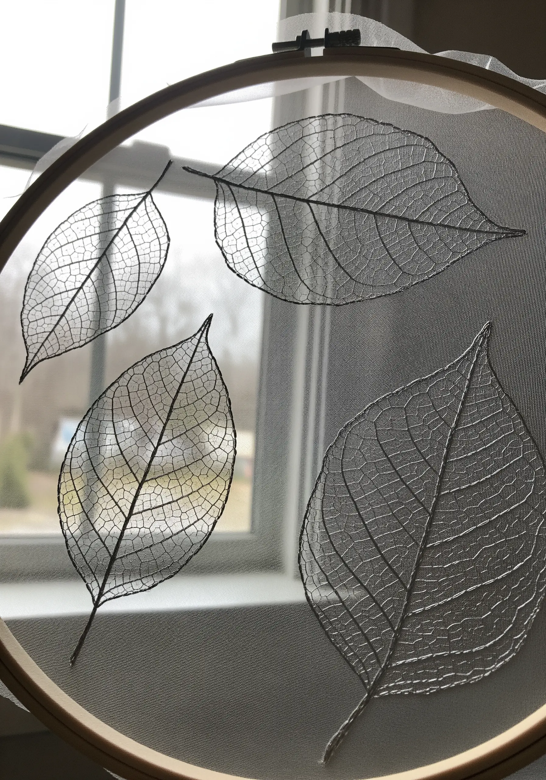 Delicate skeleton leaves embroidered with fine black thread on sheer tulle