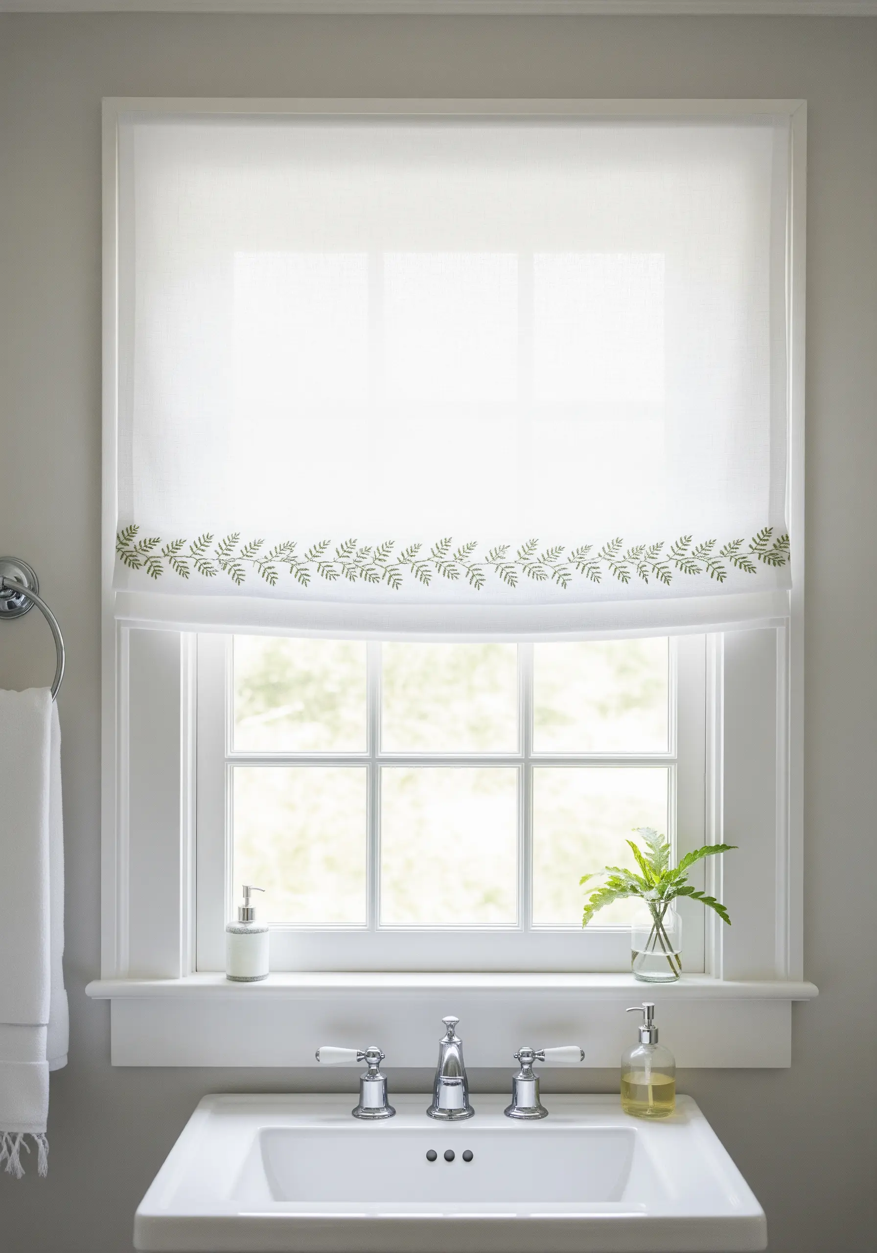A delicate green fern embroidery border stitched along the bottom of a white window shade.