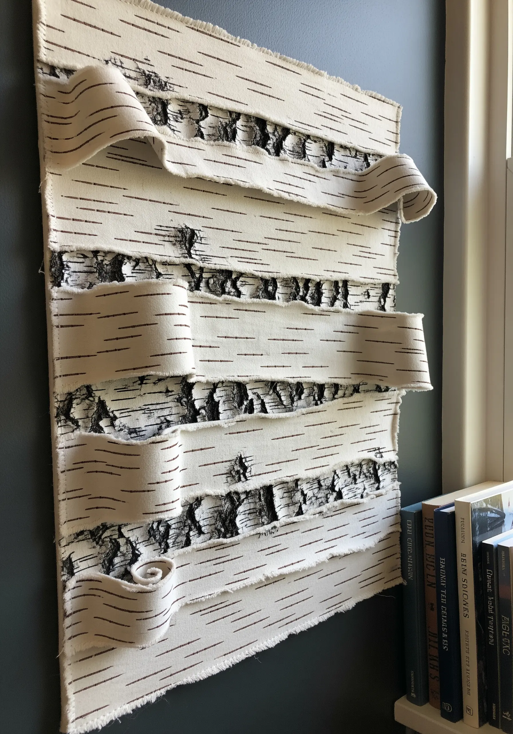 Textile wall art mimicking birch bark, with peeled and curled layers of fabric.