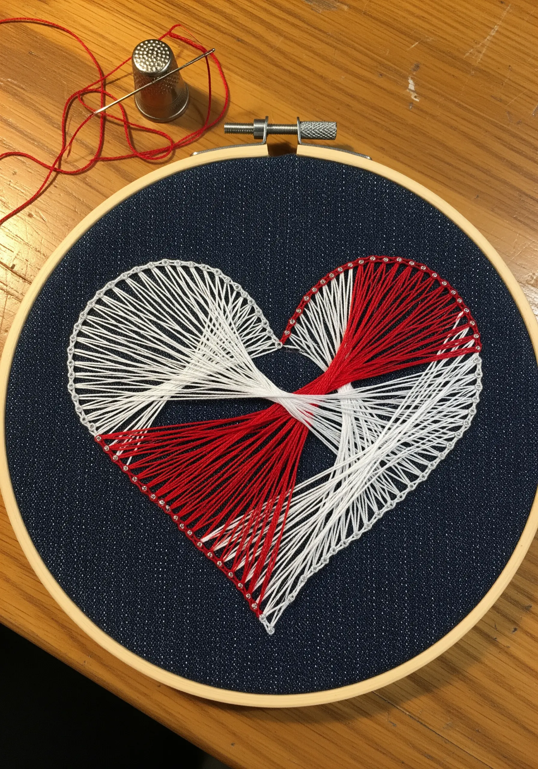 A red and white string art heart designed to look like two halves tied together in the center.