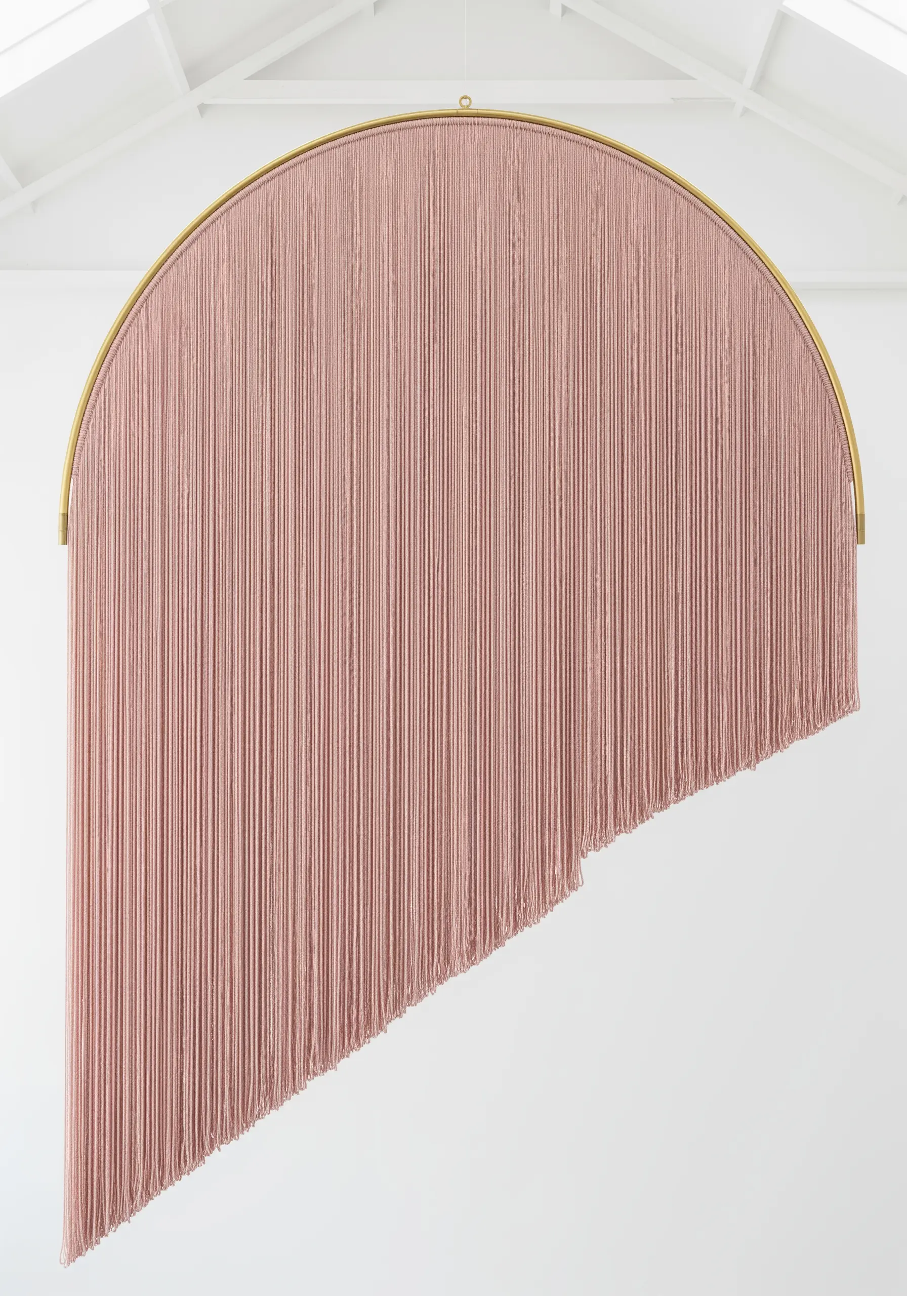 A large, arched frame with a long, pink fringe cut in a diagonal line.