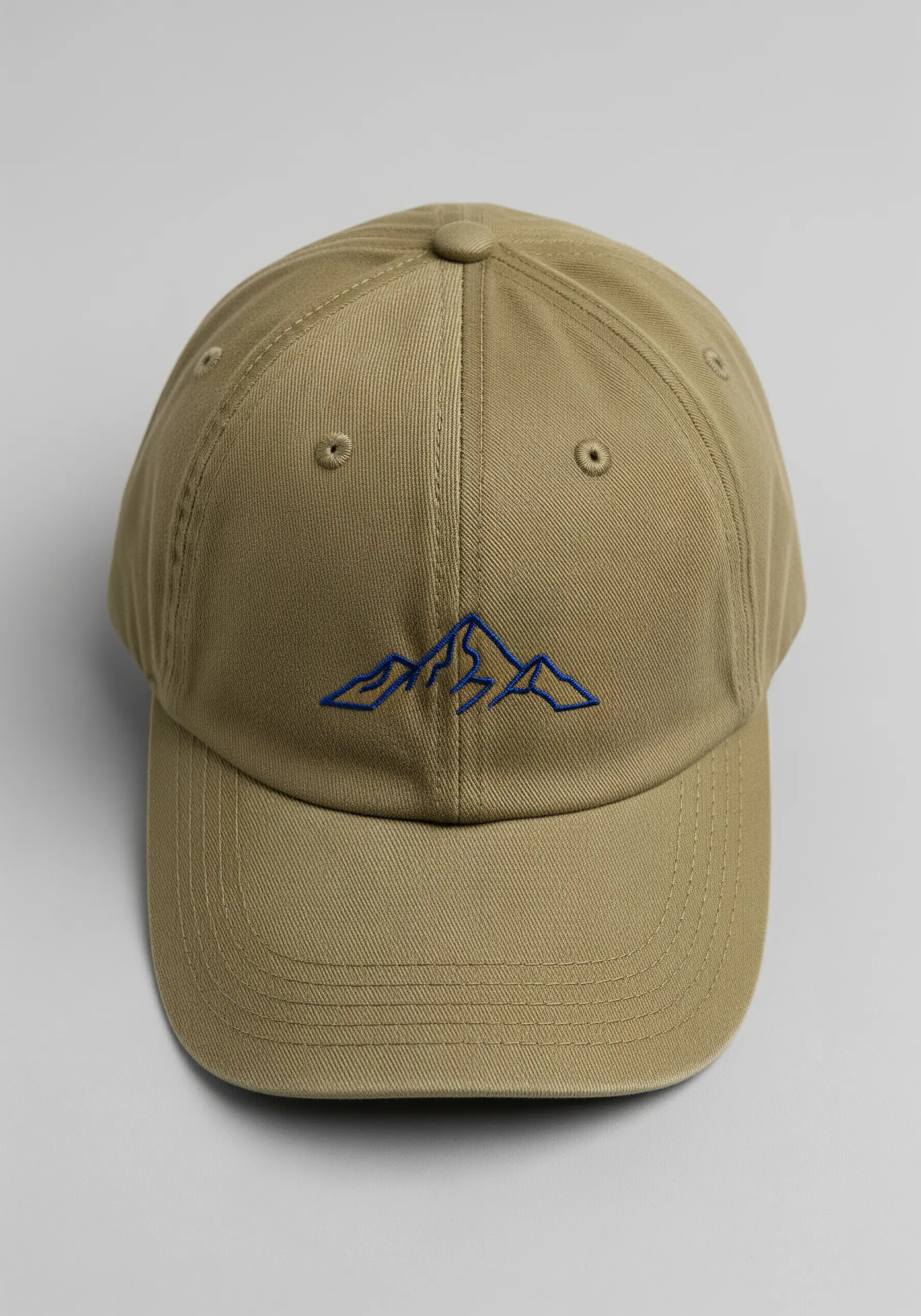 Minimalist blue outline of a mountain range on a khaki baseball cap.