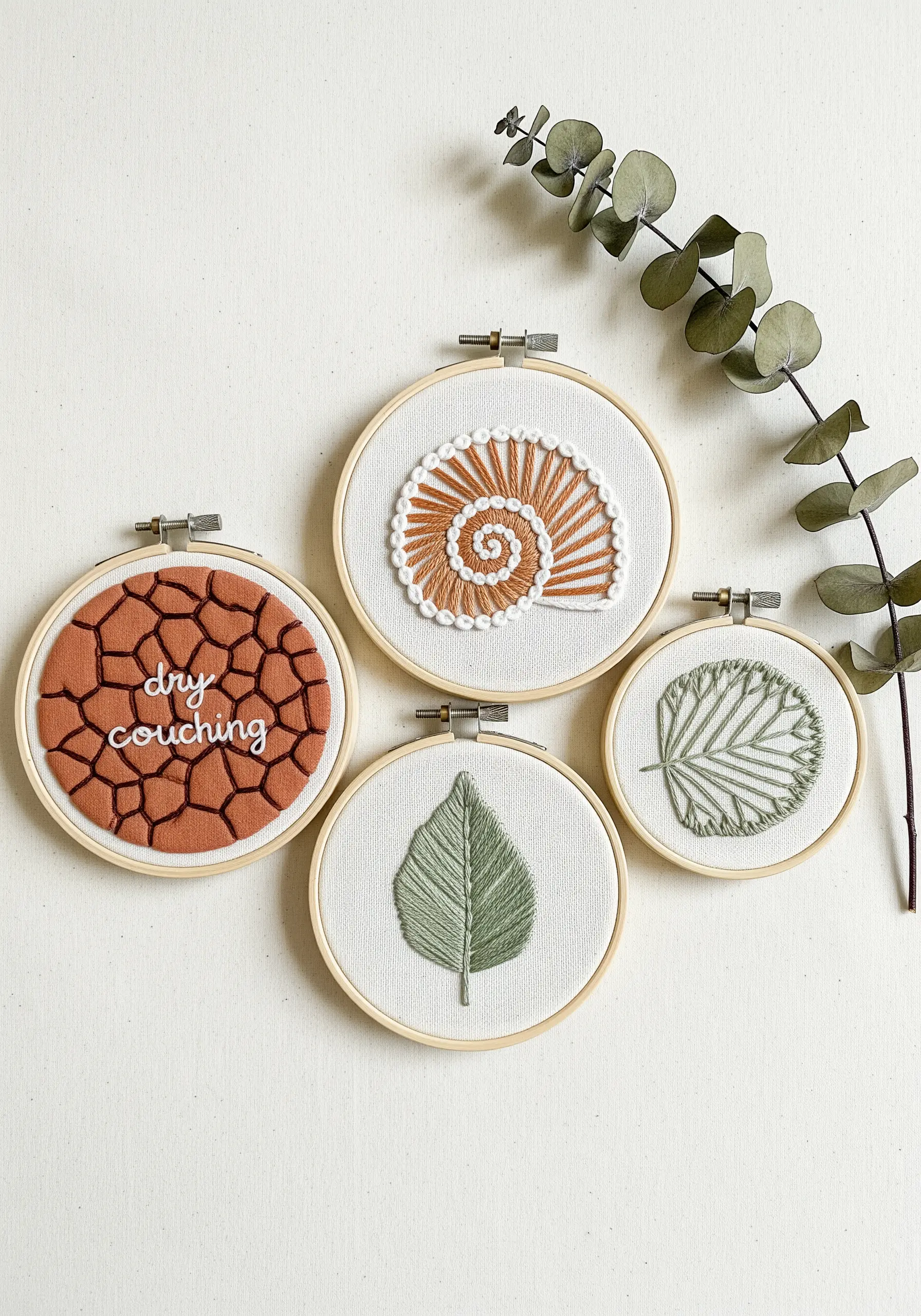 A collection of four embroidery hoops demonstrating couching, satin stitch, and fishbone stitch.