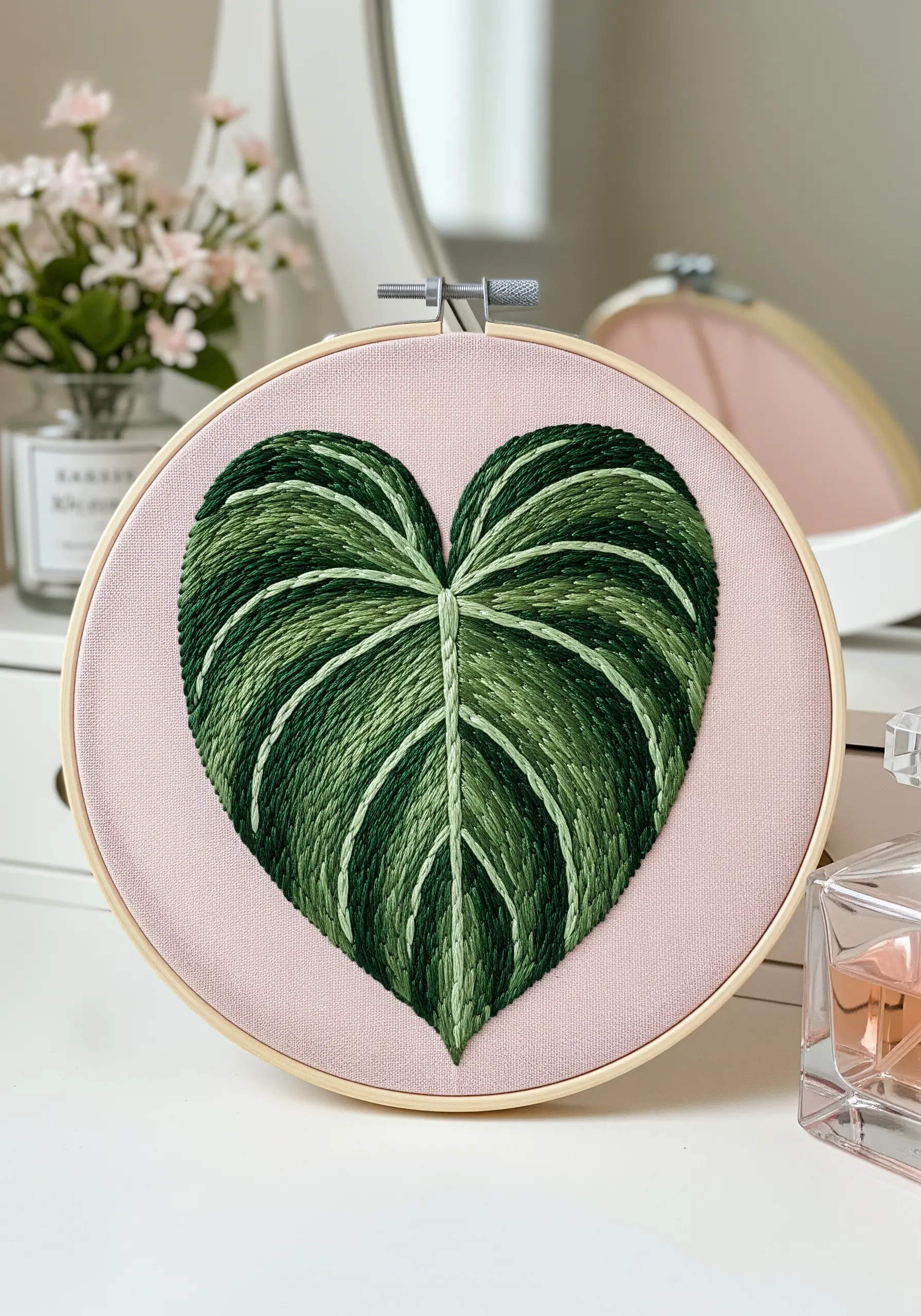 A heart-shaped leaf with variegated green stripes and curved long-and-short stitches.