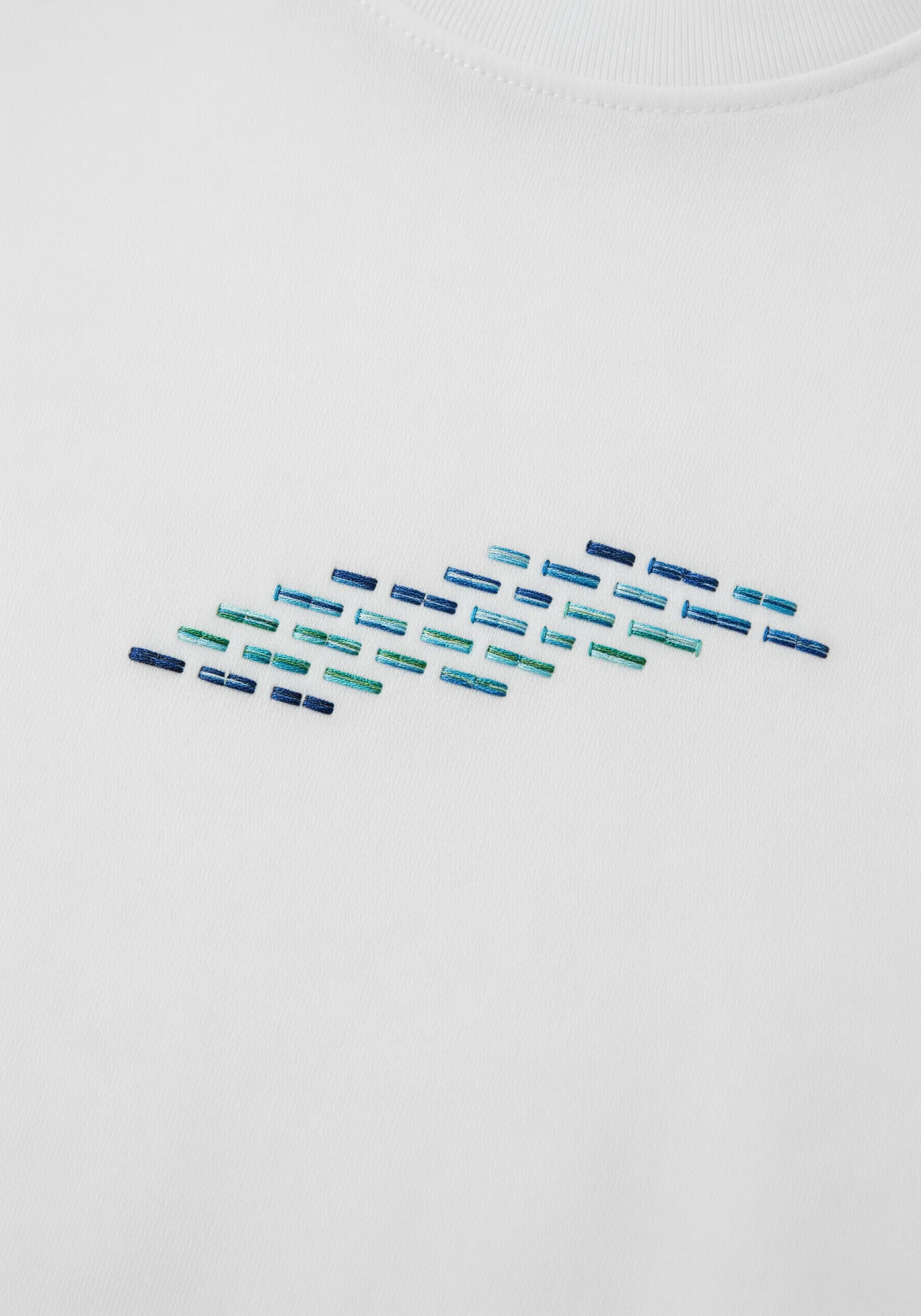 An abstract school of fish created with small, horizontal stitches in shades of blue.