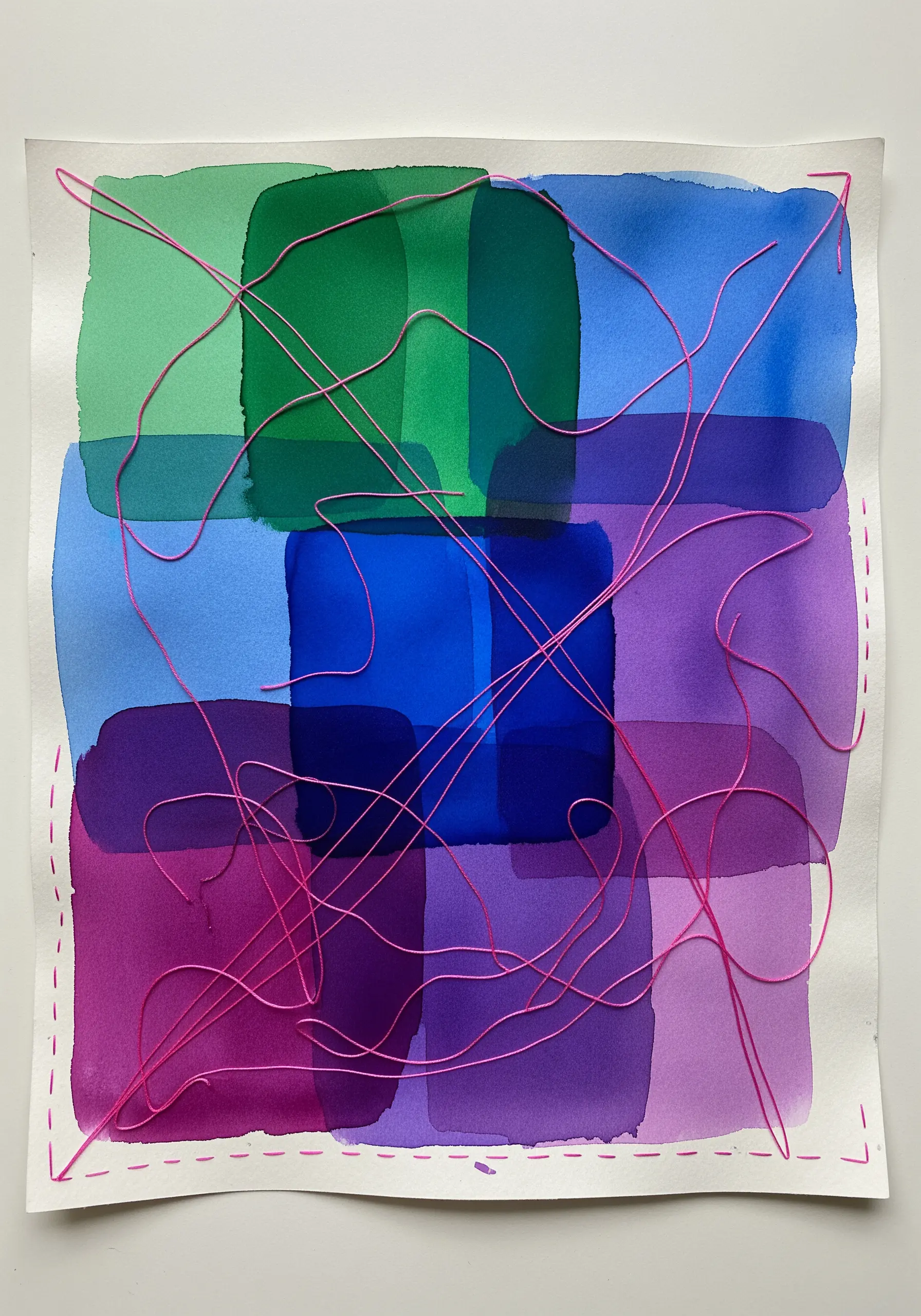 Abstract watercolor painting with pink thread couched loosely over the surface.