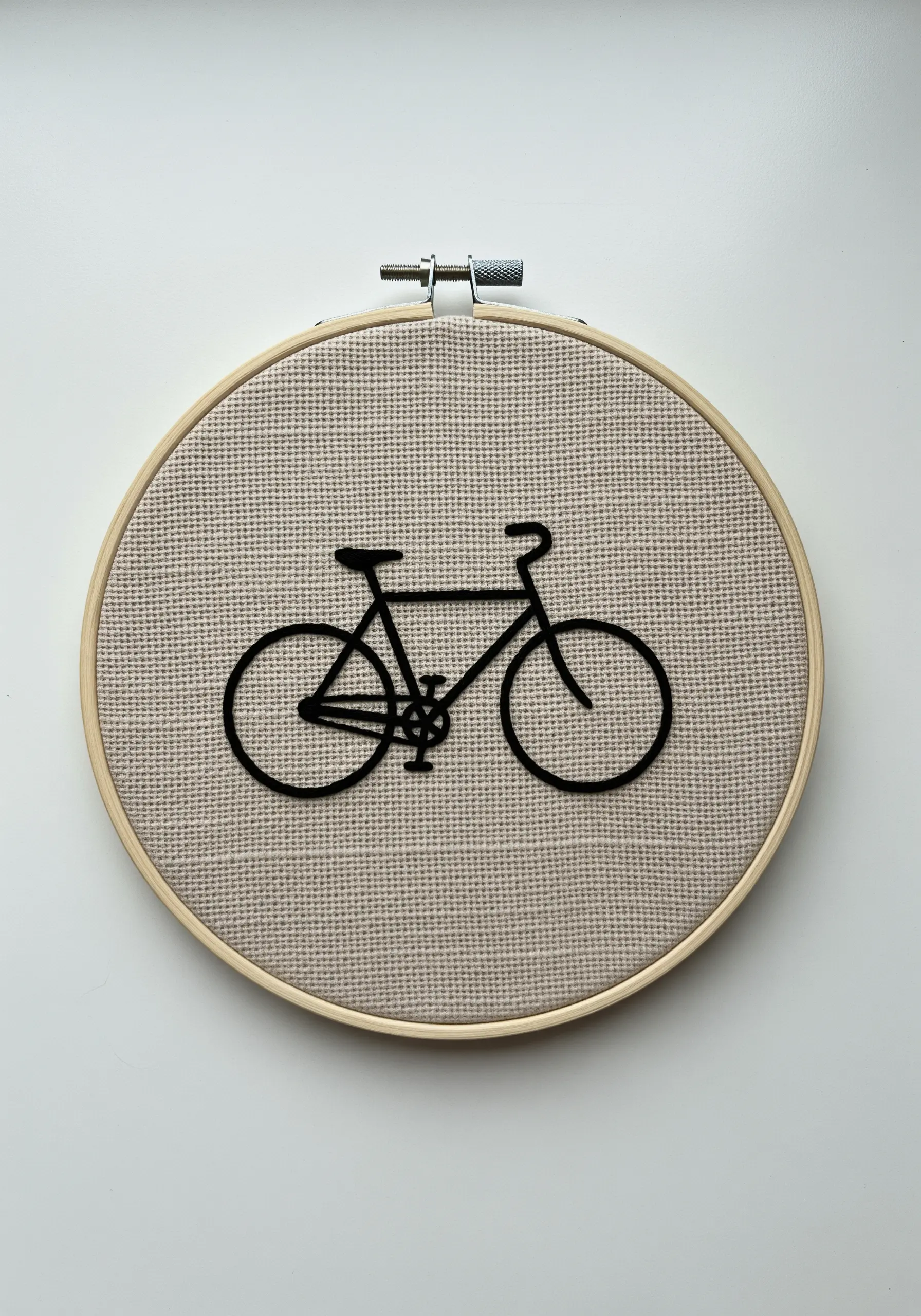 A clean, modern silhouette of a bicycle embroidered in black whipped backstitch.