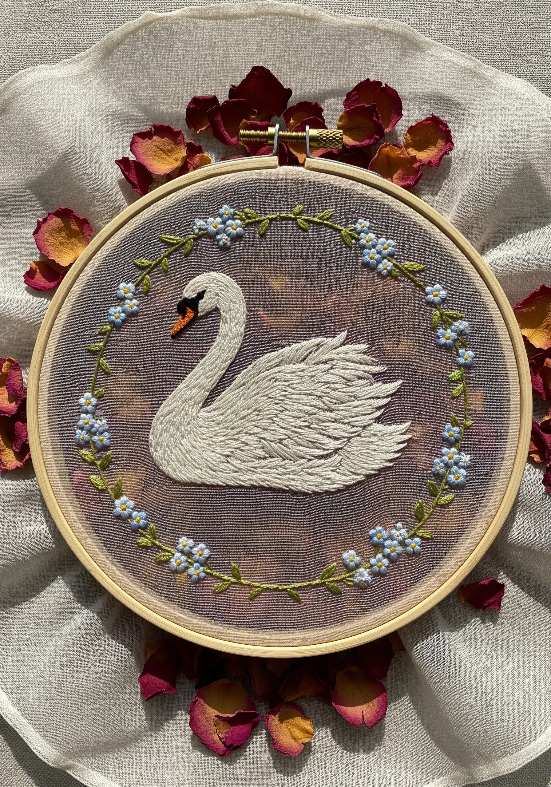 A white swan with textured feathers embroidered on sheer fabric, displayed in a hoop.