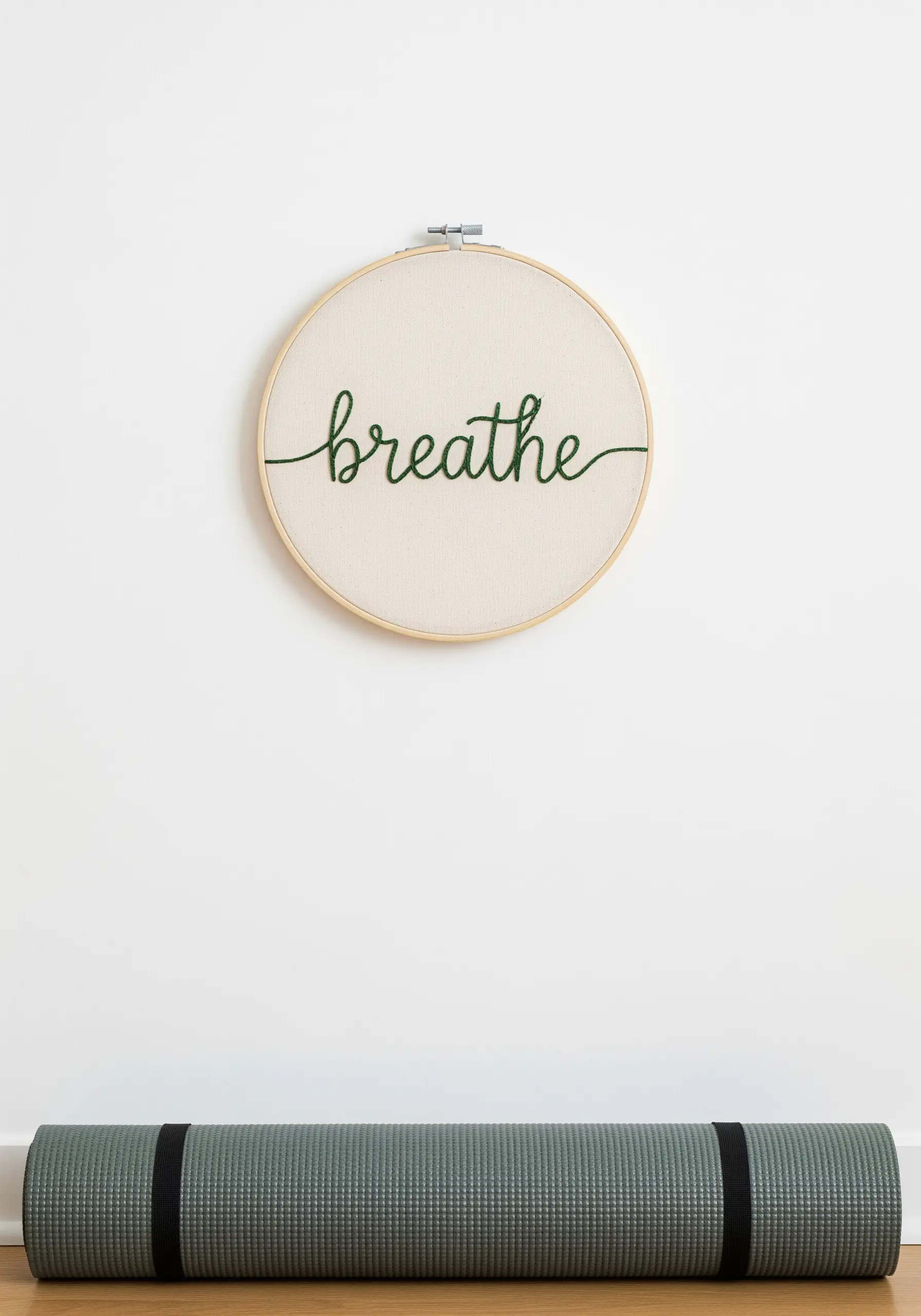 Minimalist embroidery of the word 'breathe' in green cursive script.