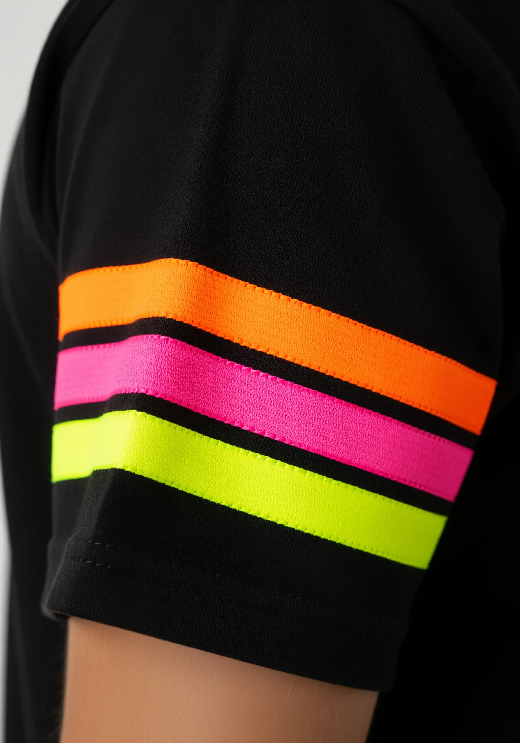 Clean, bold stripes in neon yellow, pink, and orange on the sleeve of a black t-shirt.
