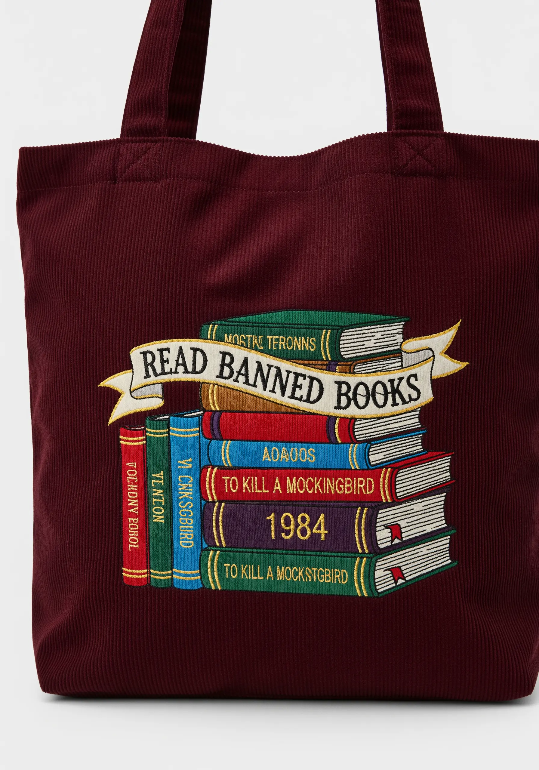 Embroidery of a stack of books with the banner 'Read Banned Books' on a corduroy tote.