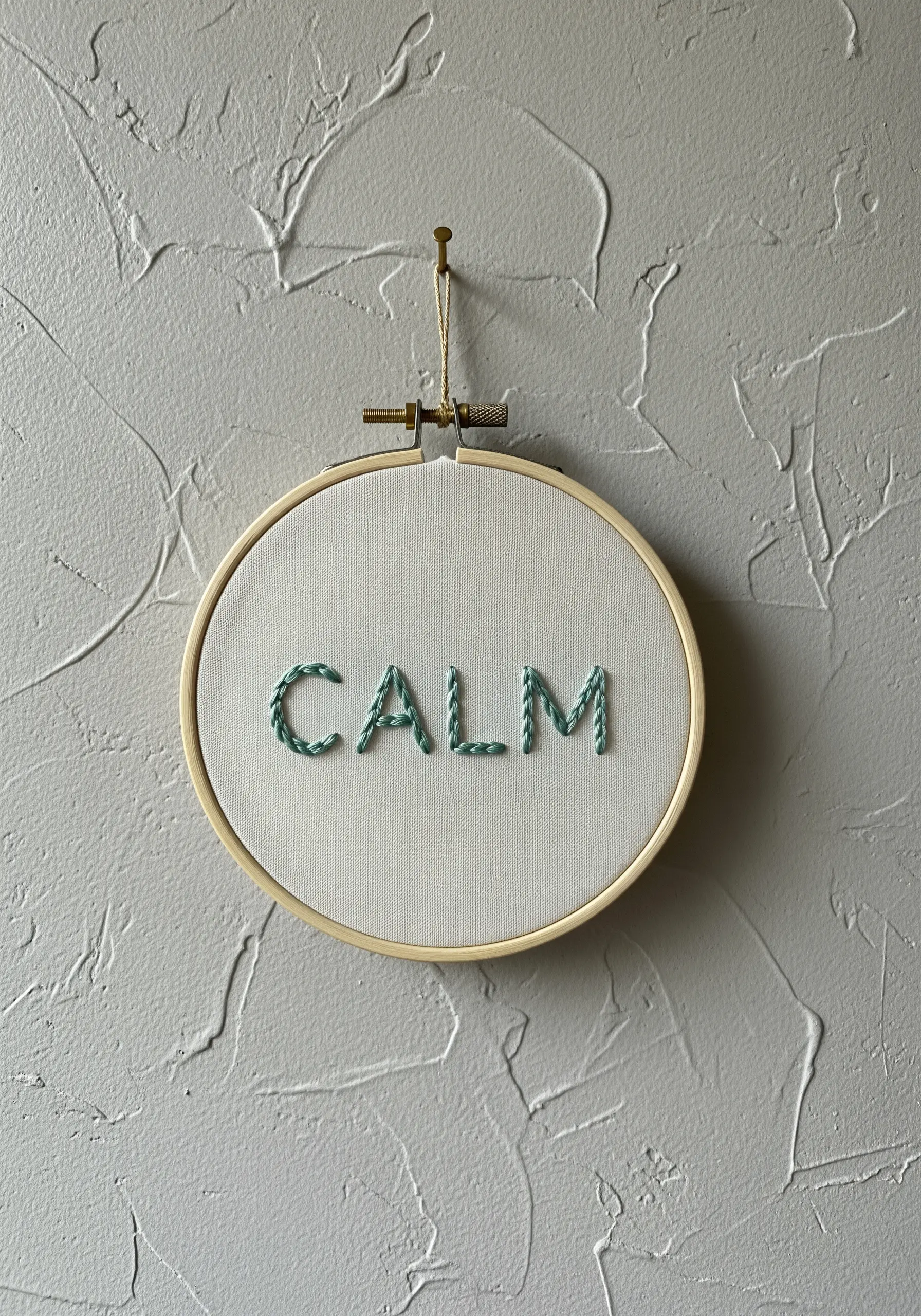 The word 'CALM' stitched in a two-toned green twisted stitch.