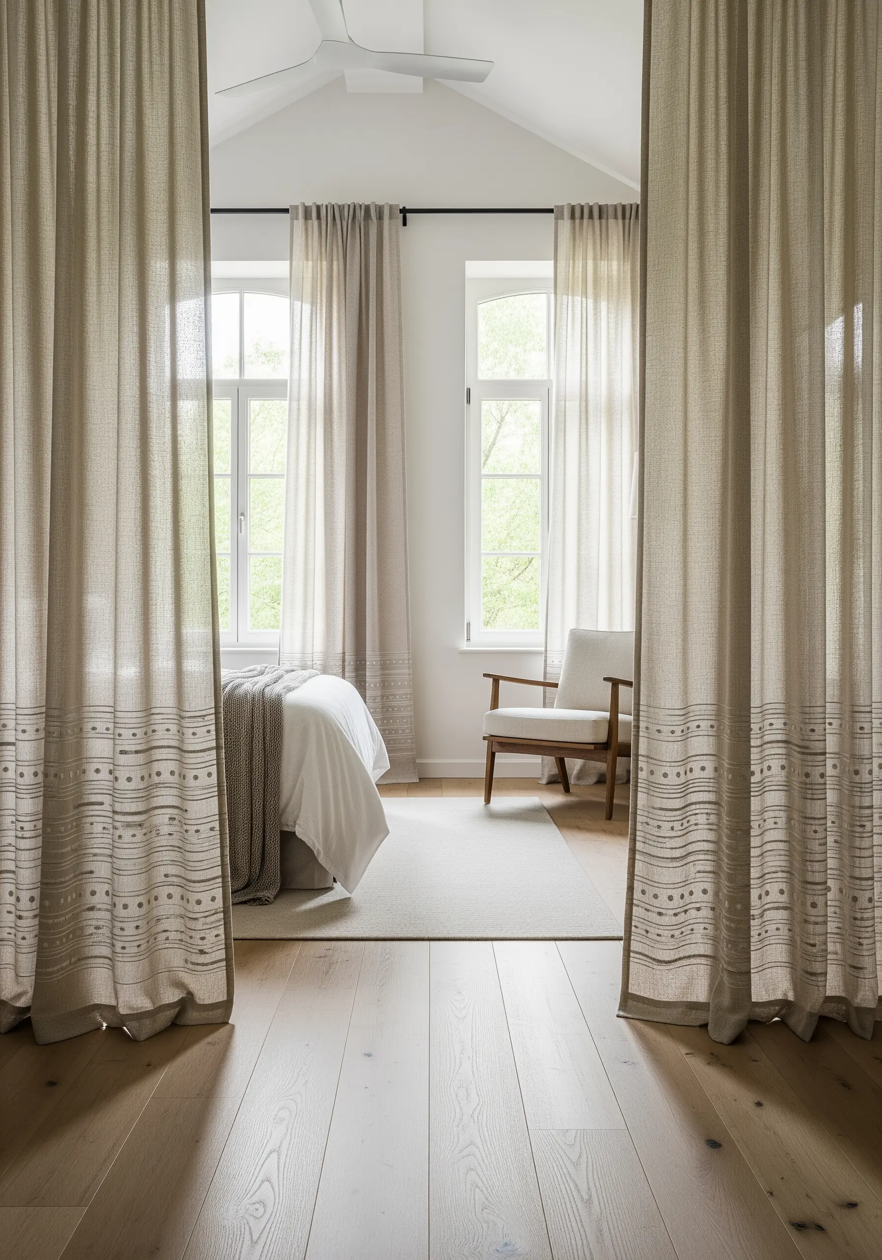 Sheer linen curtains with a subtle geometric embroidered border pattern.