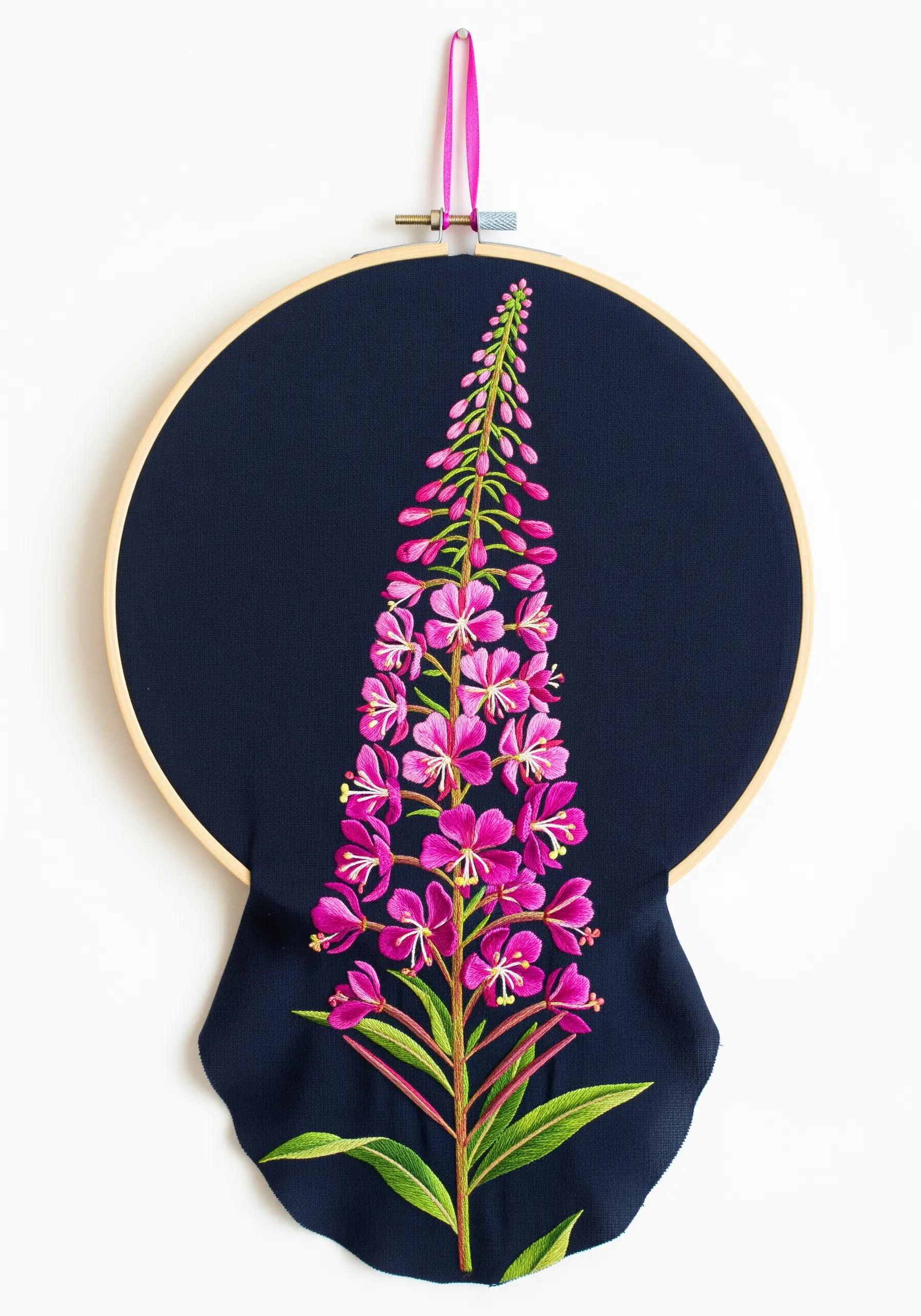 Bright pink fireweed stalk embroidered on dark navy fabric that drapes below the hoop.
