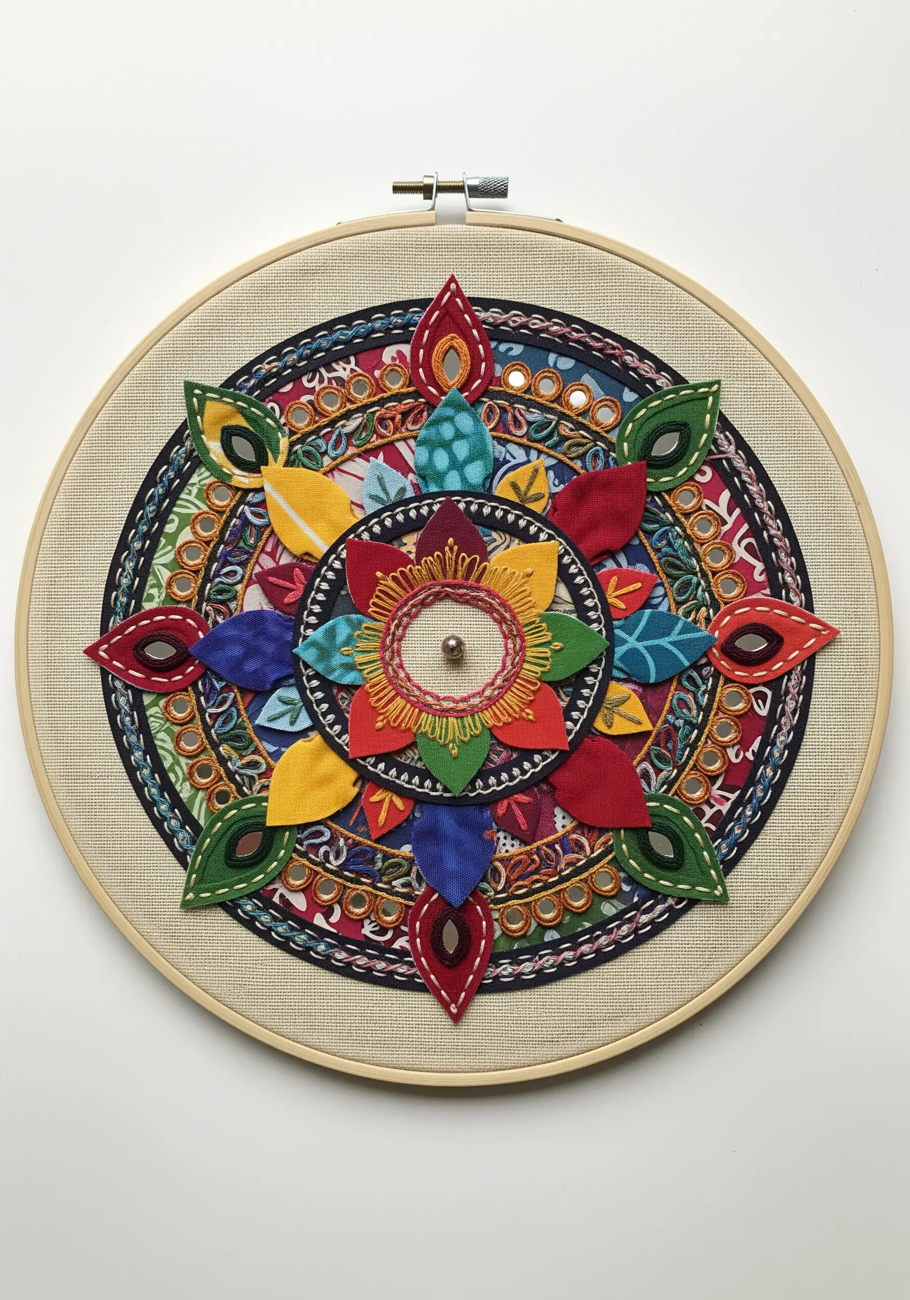 Fabric appliqué mandala in a hoop with decorative running stitches and shisha mirrors.