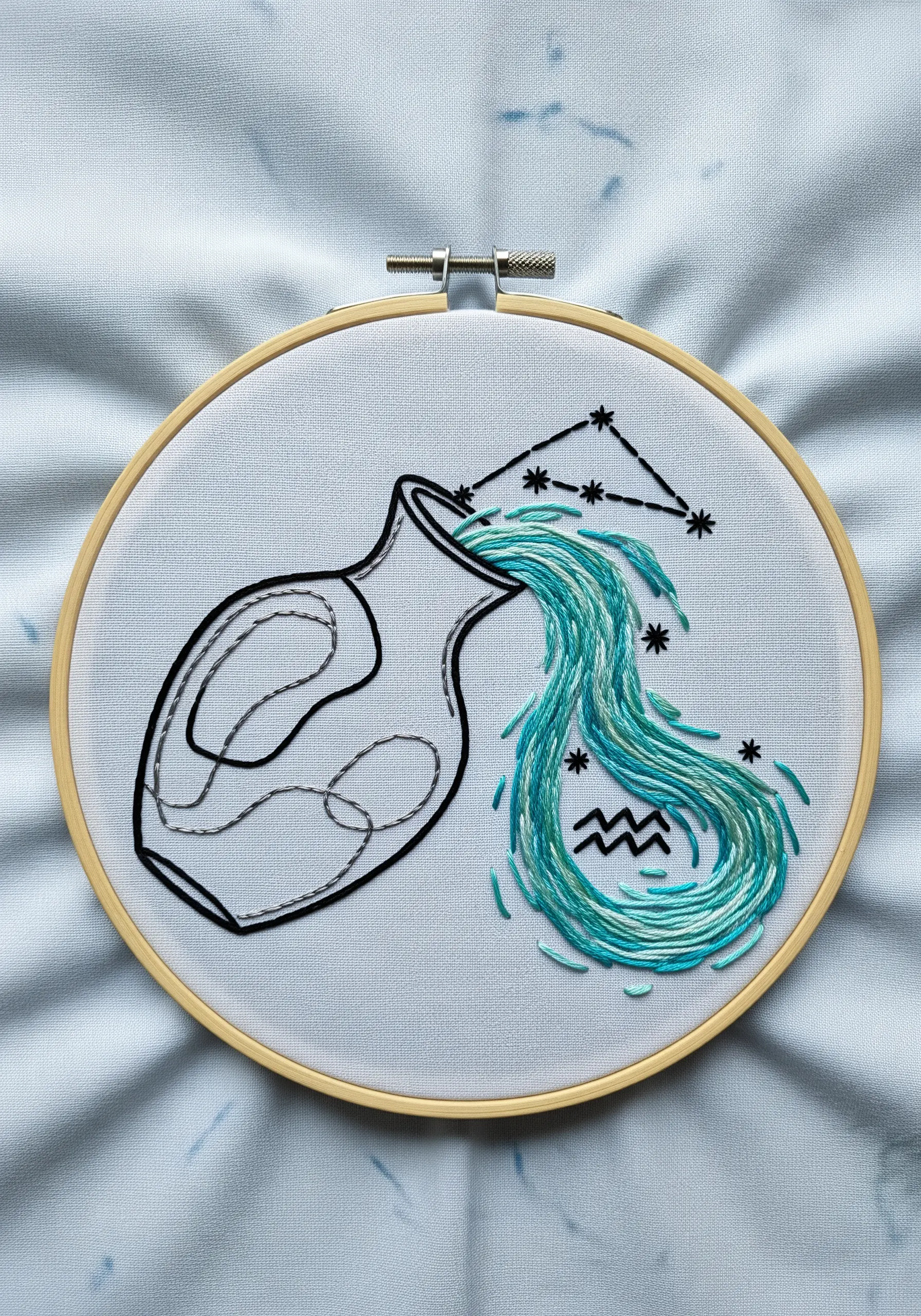 Aquarius water bearer hoop art with water stitched in flowing blue and teal threads.