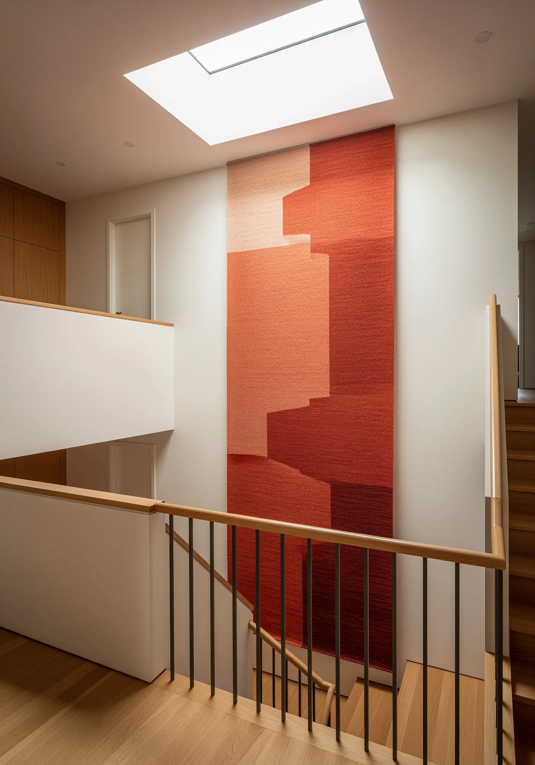 A very large textile hanging with geometric color blocks in shades of red and orange.