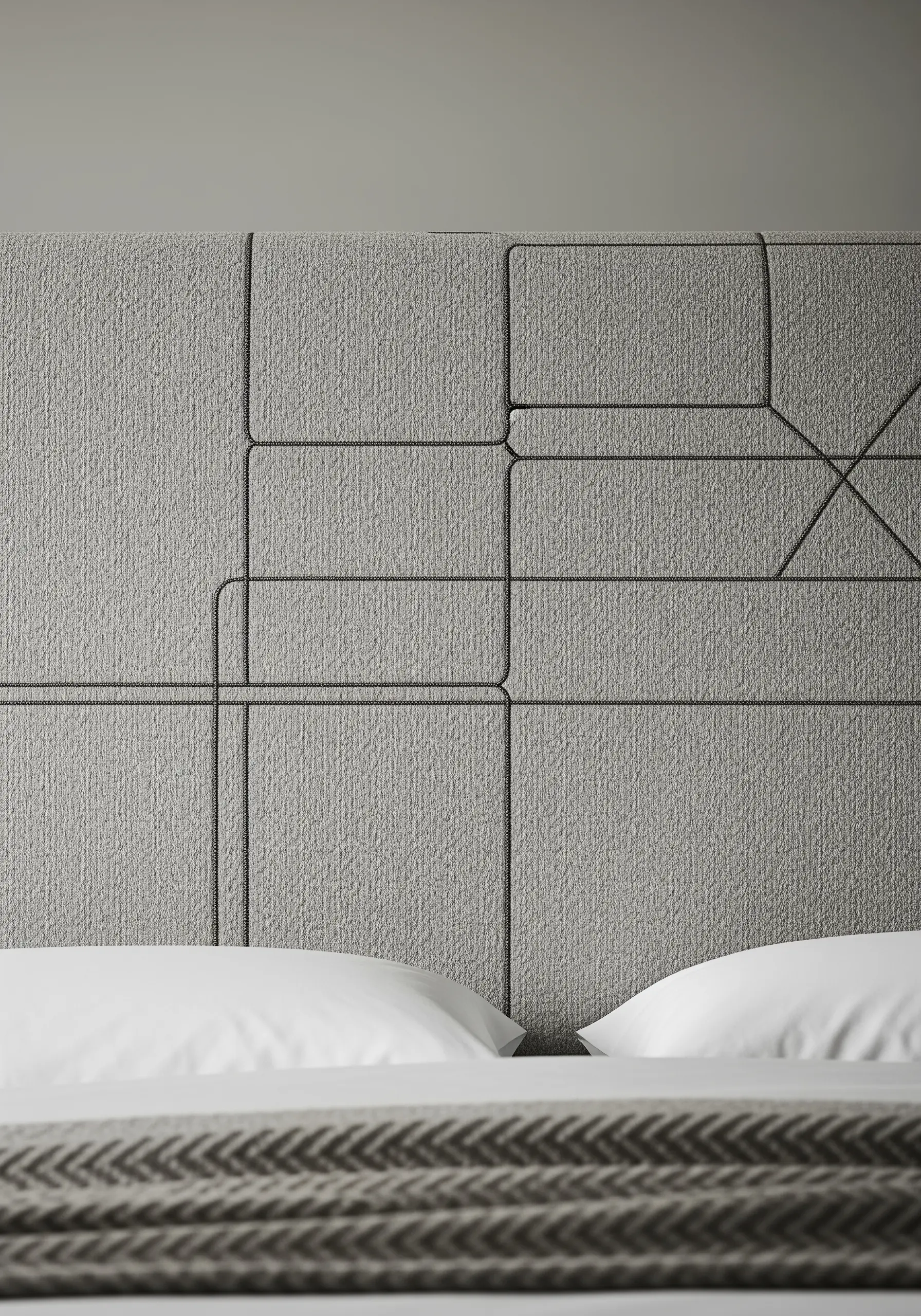 A gray upholstered headboard with an inset geometric line pattern.