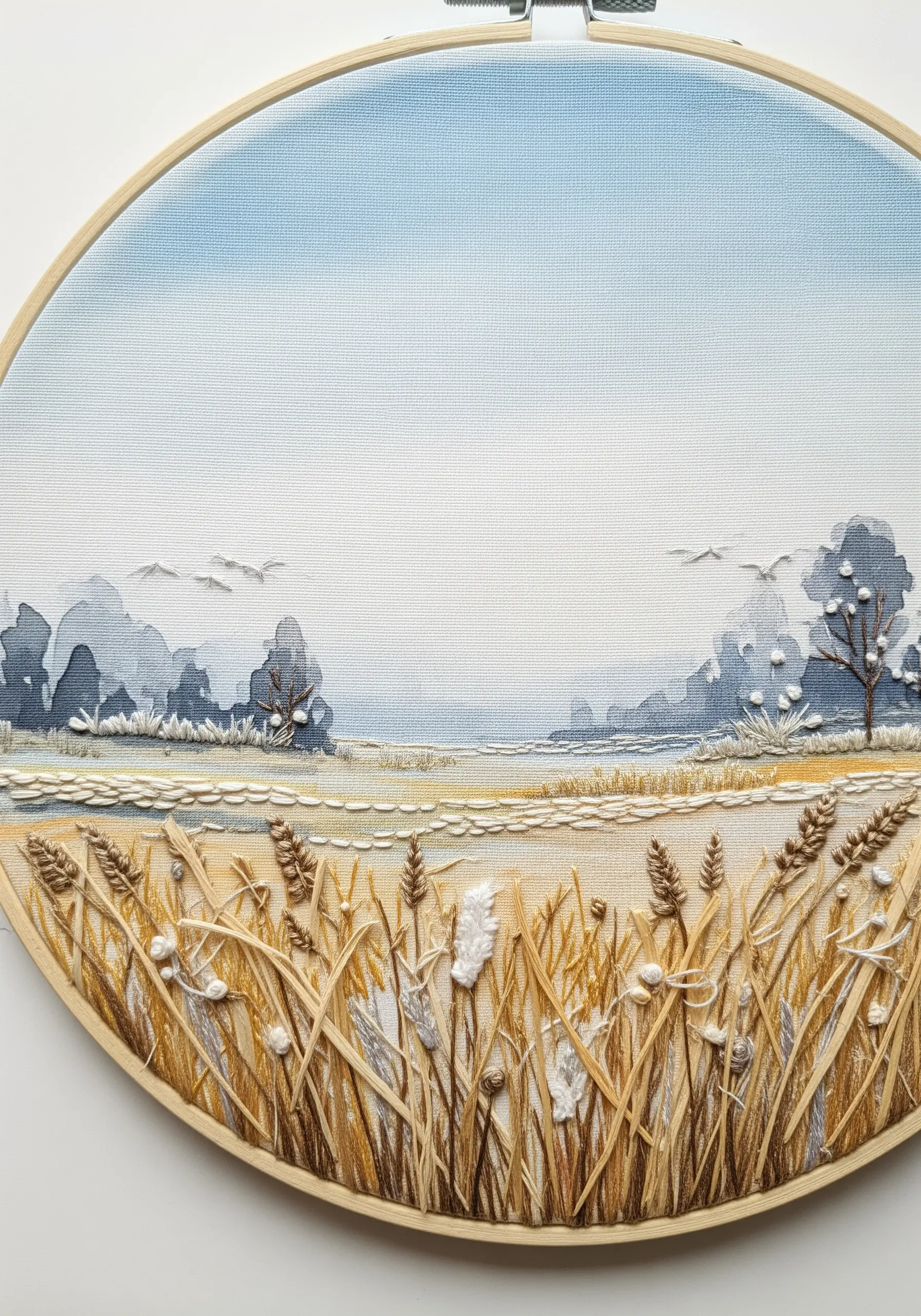 Embroidered landscape with a watercolor-painted sky and stitched wheat in the foreground.