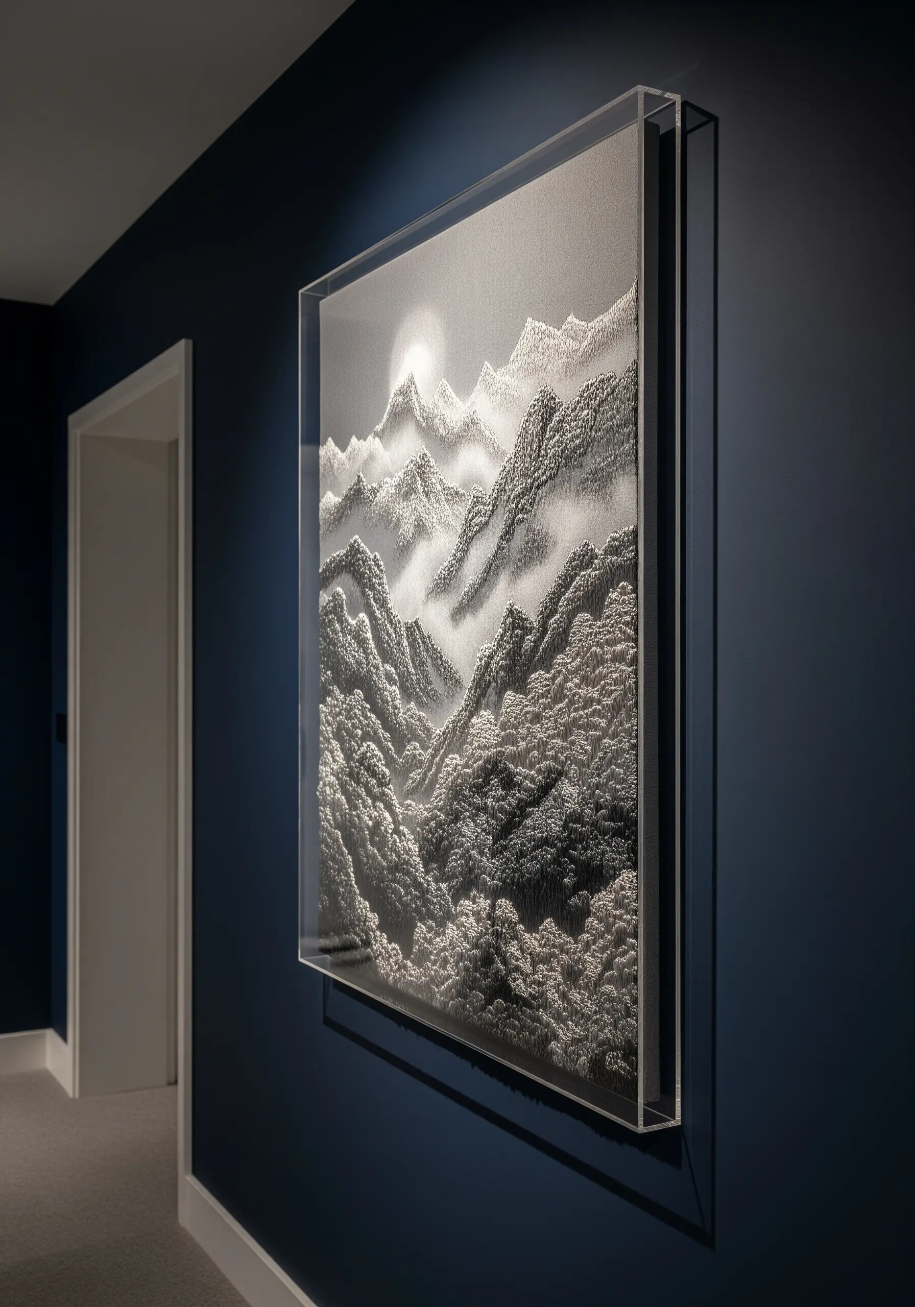 A hyper-realistic embroidered mountain landscape in grayscale, framed in clear acrylic.