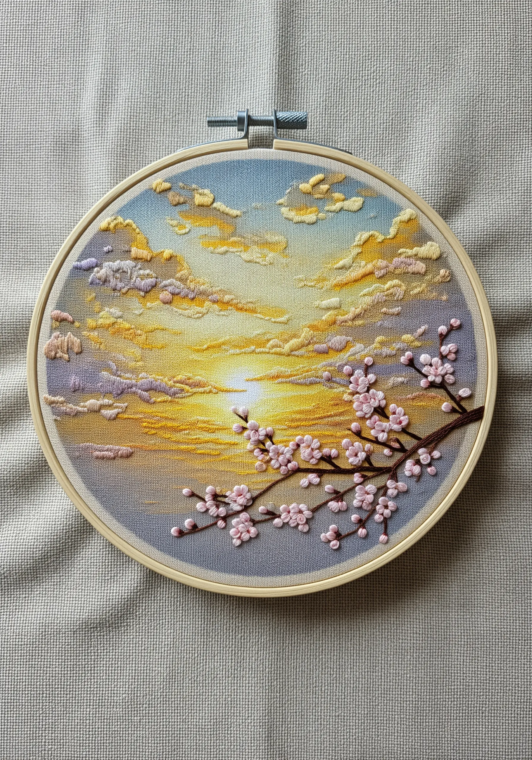 Pastel sunrise embroidery with cherry blossom branch foreground