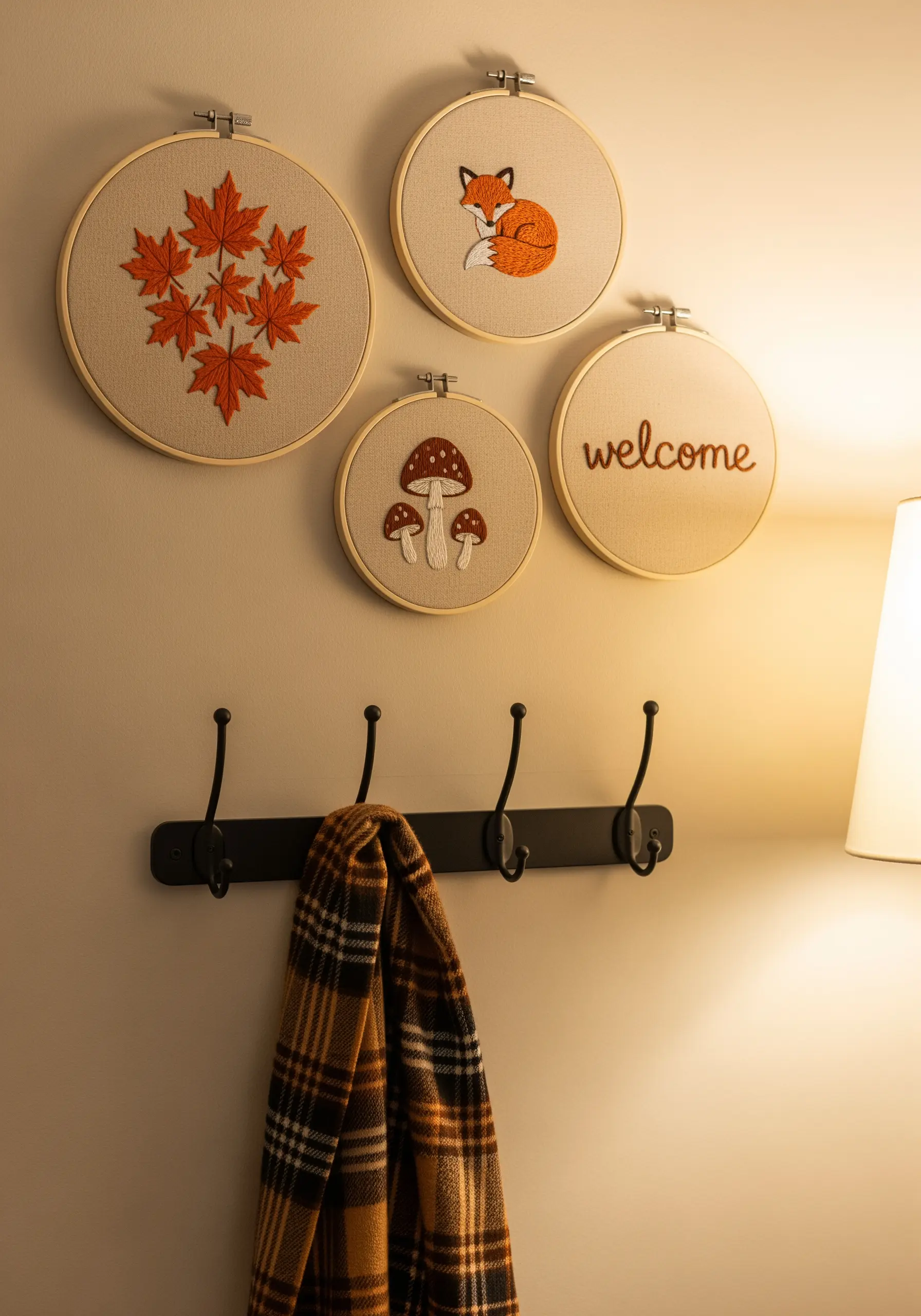 Autumnal embroidery hoops with maple leaves, a fox, mushrooms, and the word 'welcome'.