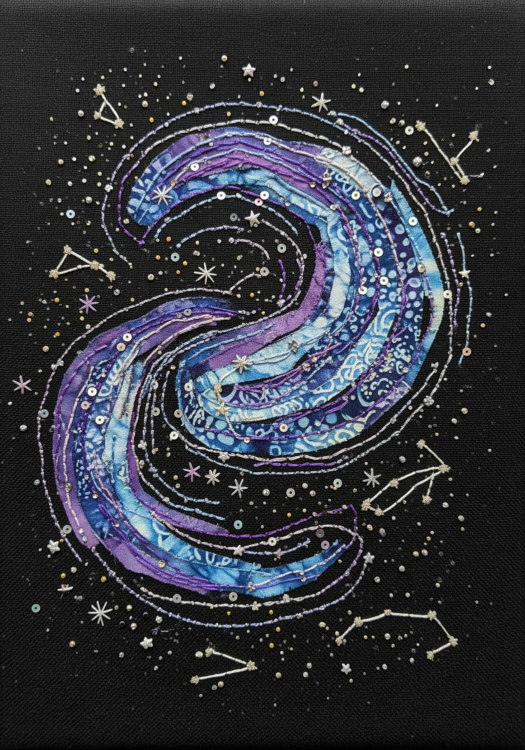 Galaxy fabric collage using batik fabric, sequins, and seed beads on a black background.