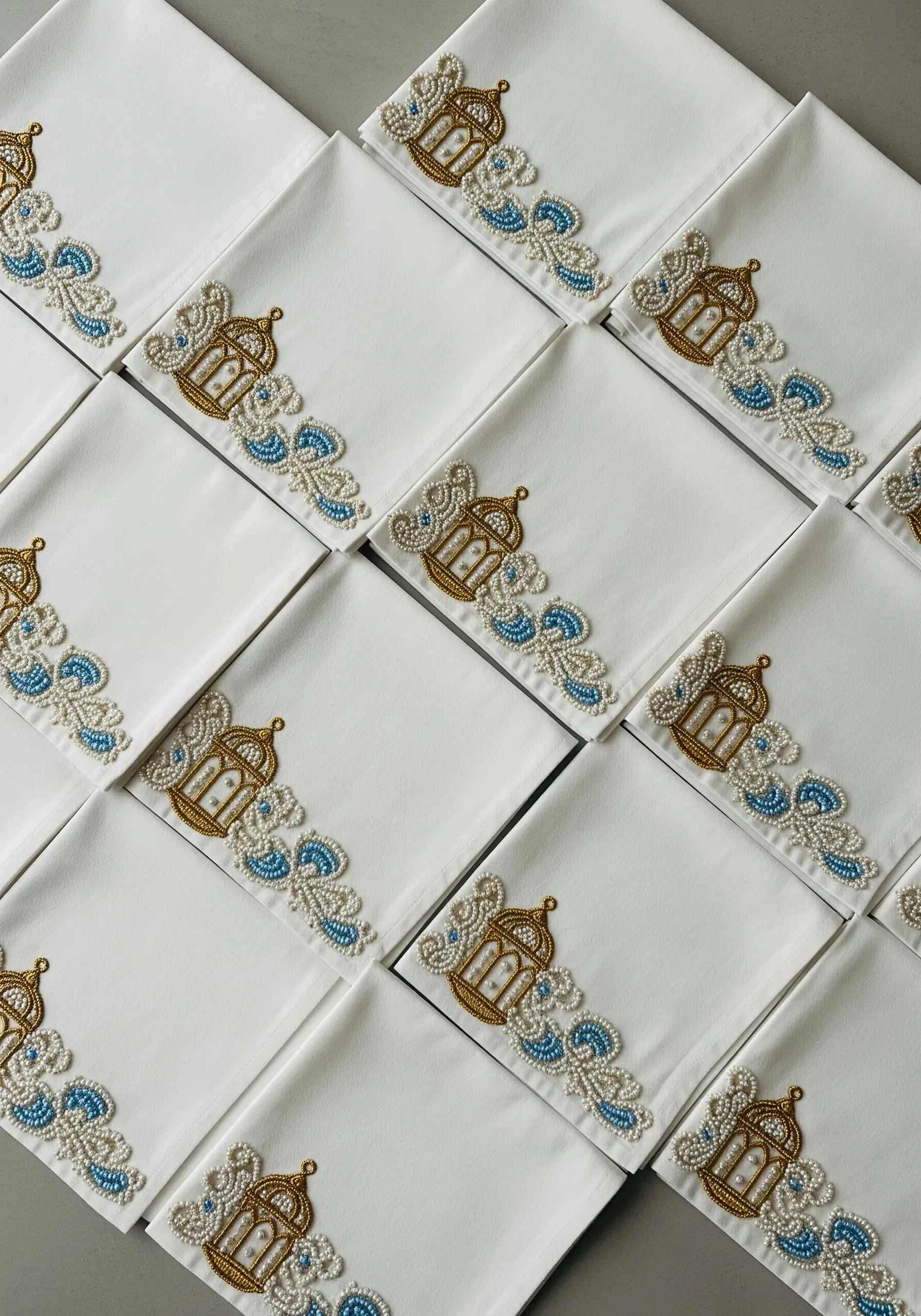 Corner motif of an embroidered gold lantern and blue swirls embellished with pearl beads.