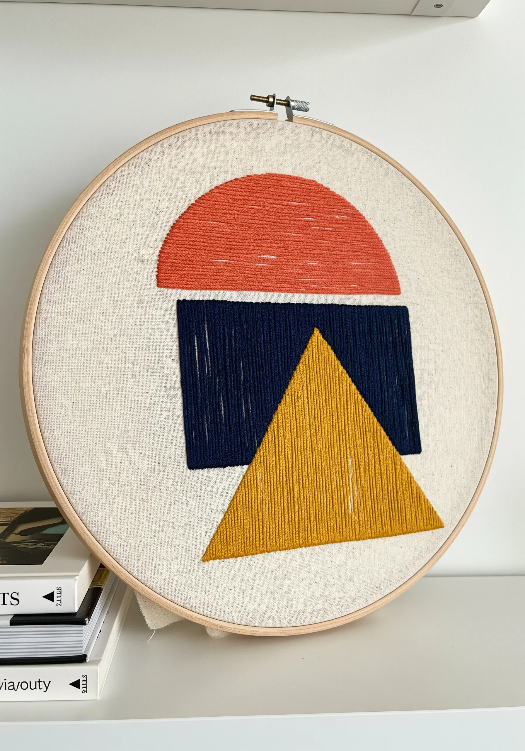 Abstract geometric shapes in red, blue, and yellow filled with vertical satin stitch.