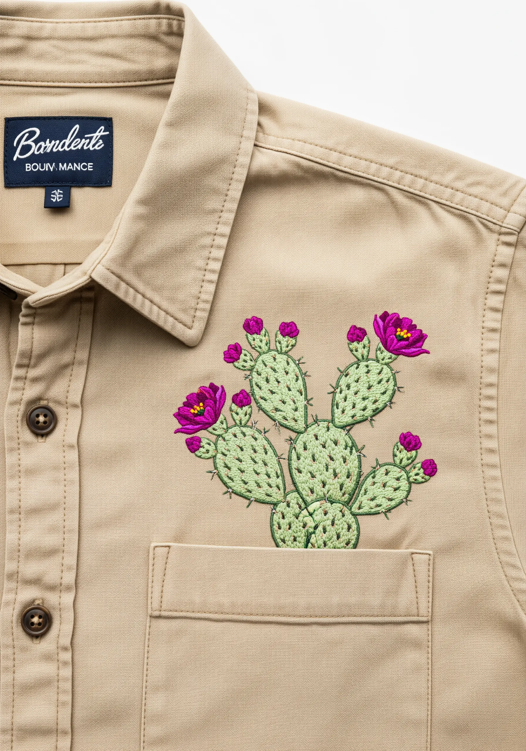 A prickly pear cactus with bright magenta flowers embroidered on a tan shirt.