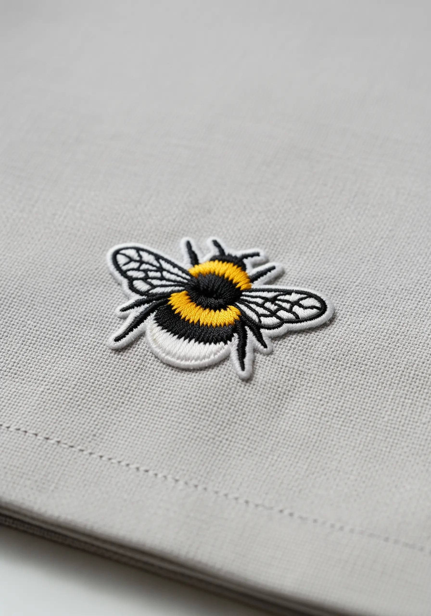 A small, detailed bumblebee embroidered patch with a raised, 3D texture.